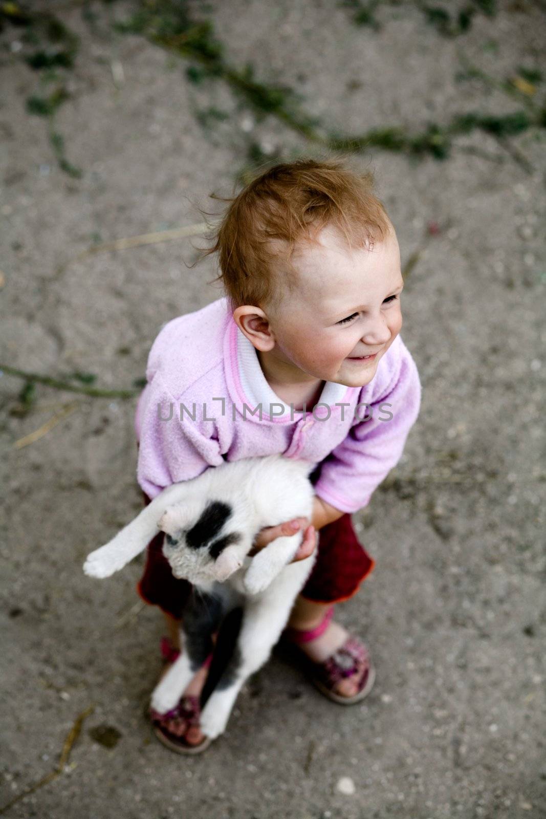The happy baby with a cat in her arms