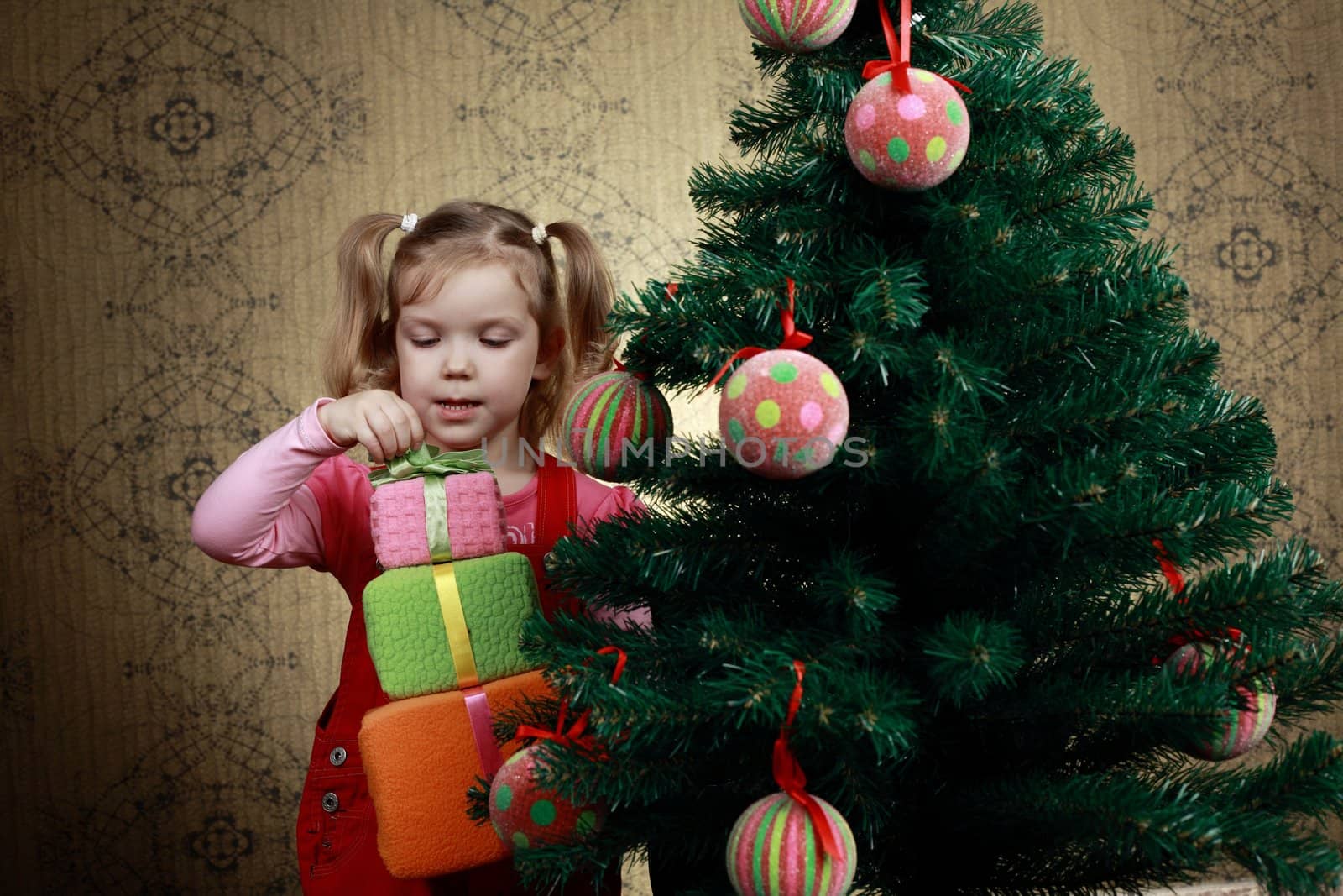 A little girl with three boxes with presents