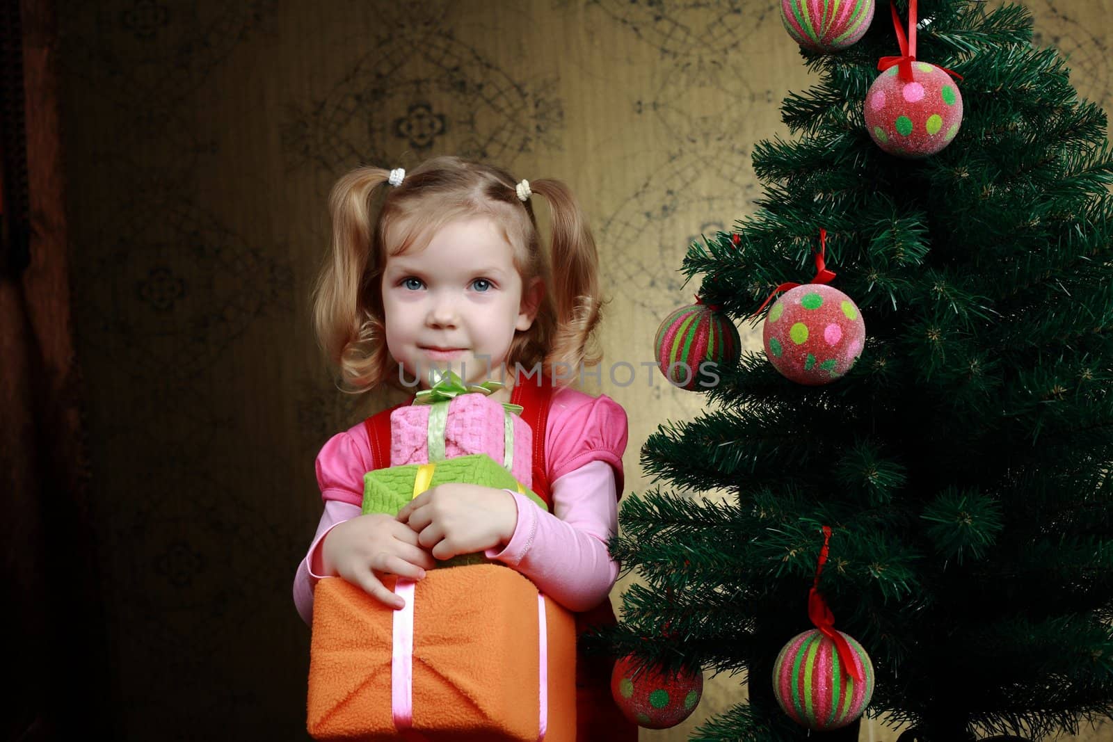 A little child with three boxes with presents