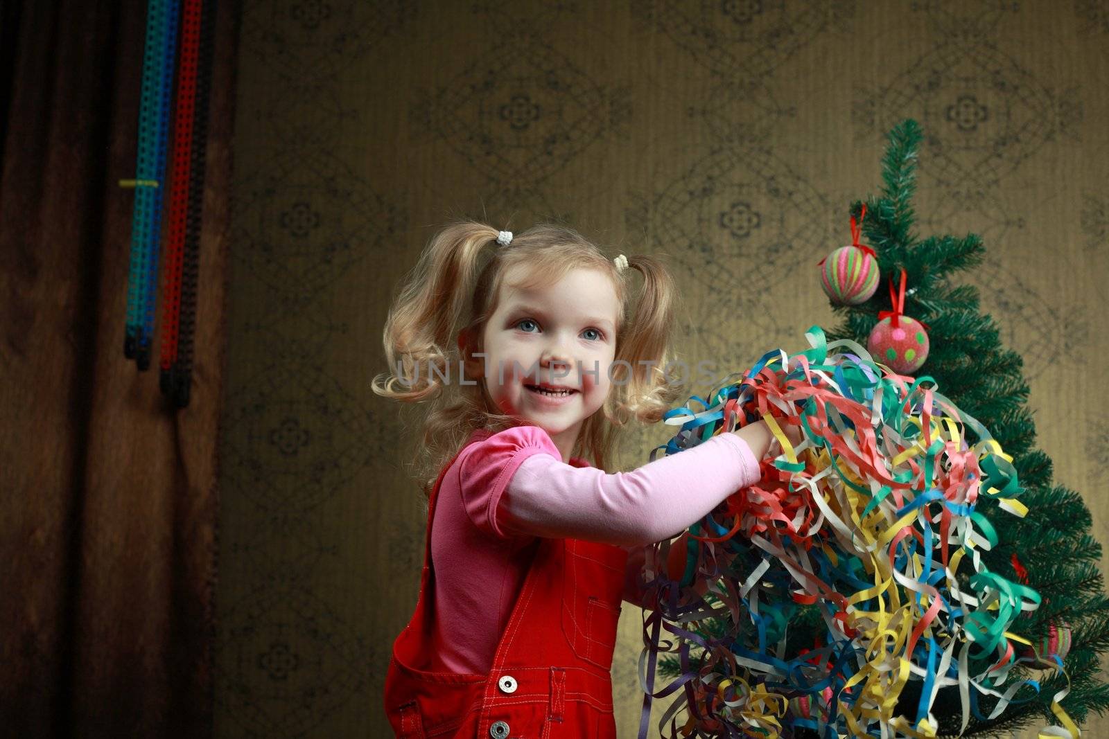A nice girl jumping at a new year tree