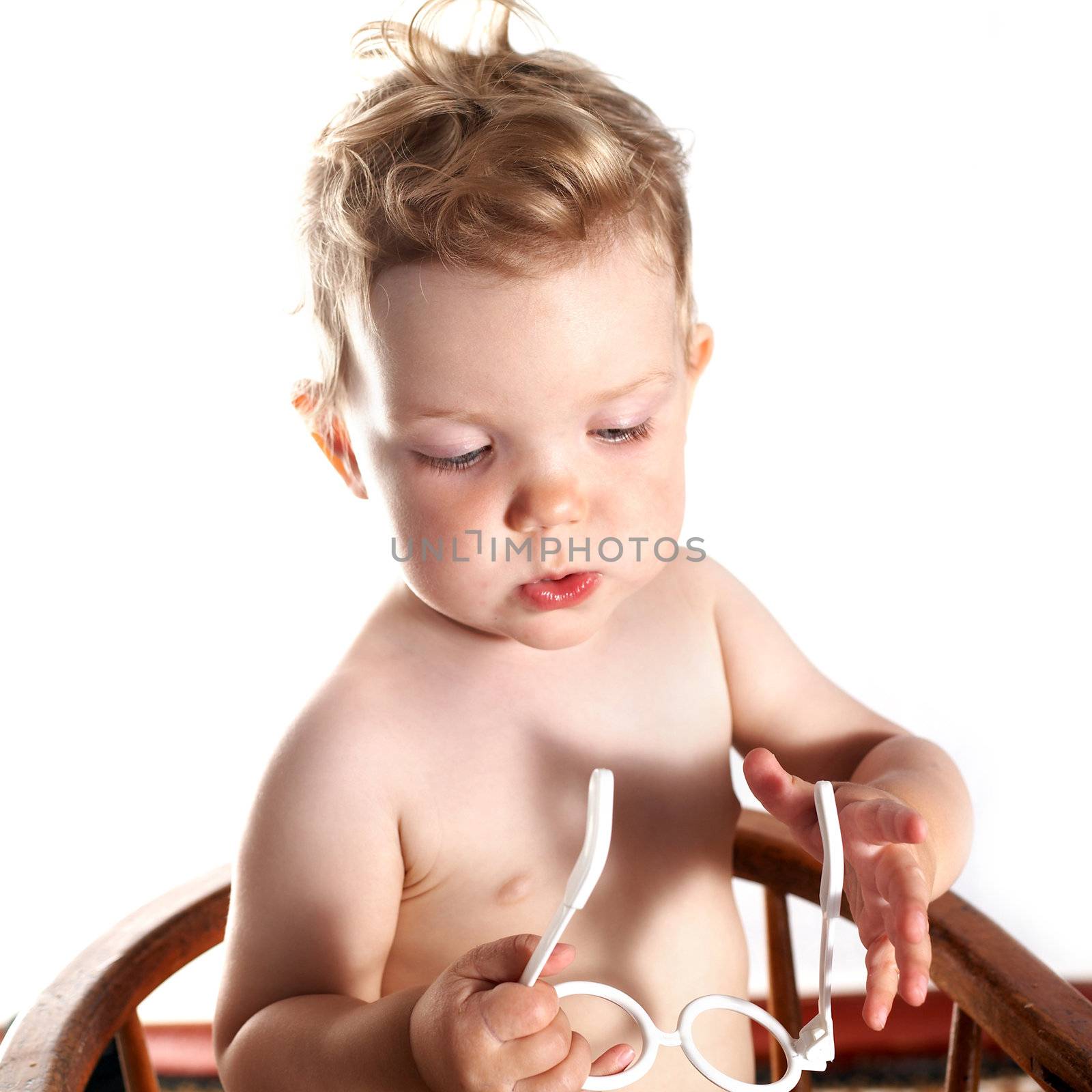 Baby-girl on white background with toy glasses