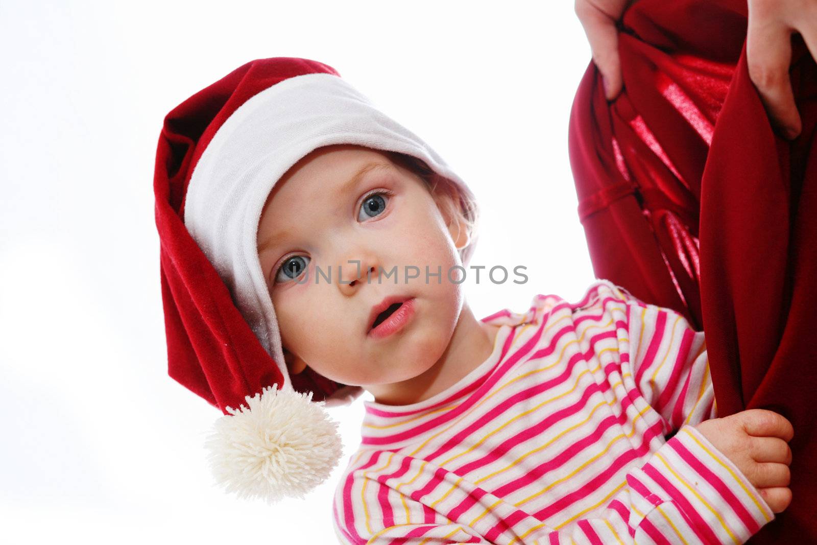 An image of surprised baby looking into christmas bag
