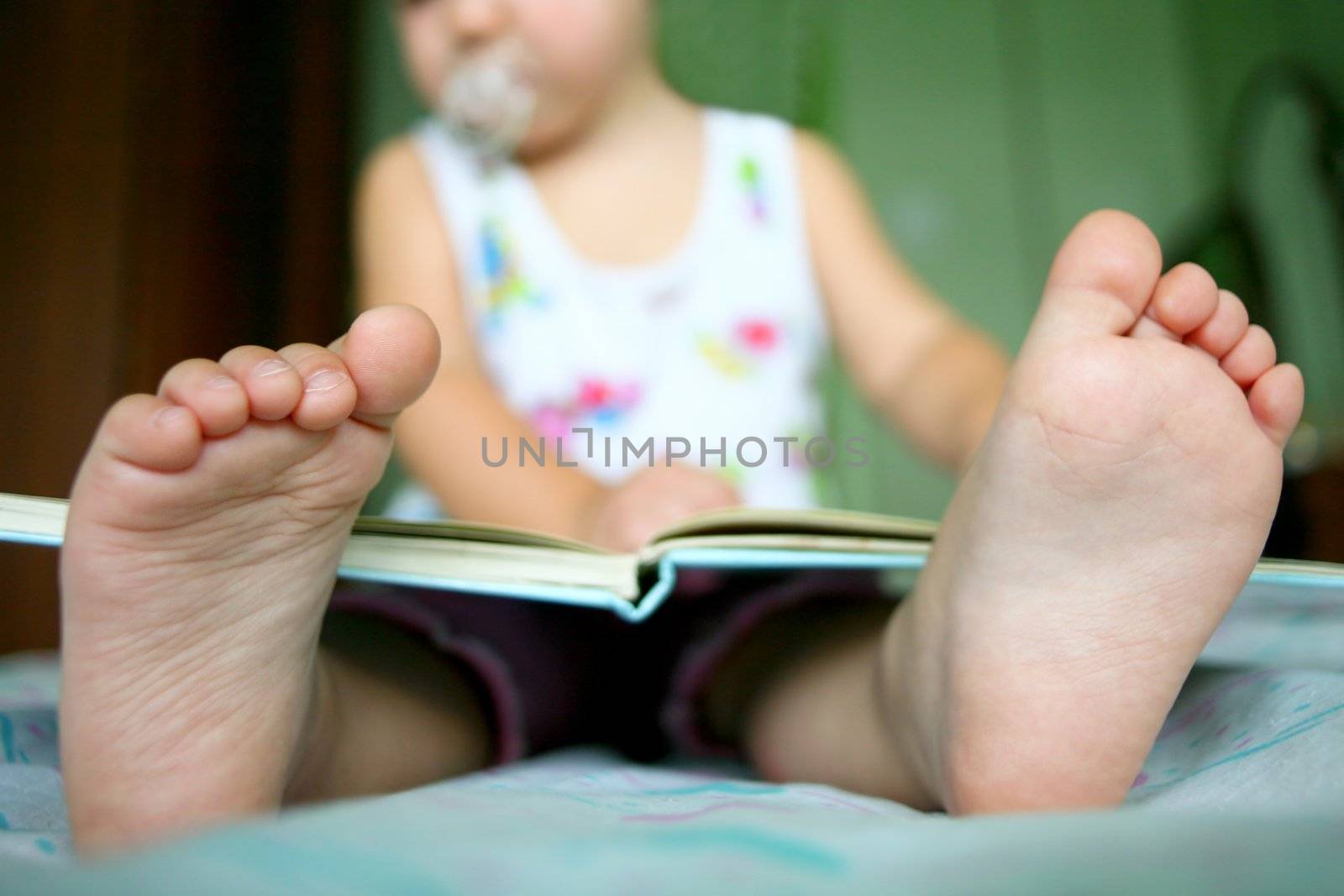 An image of a baby girl reading a book