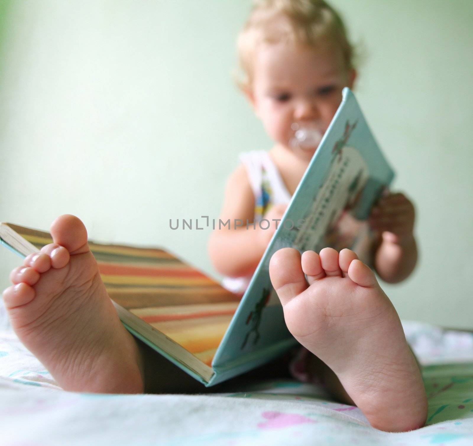 An image of a toddler reading a book. Foots closeup