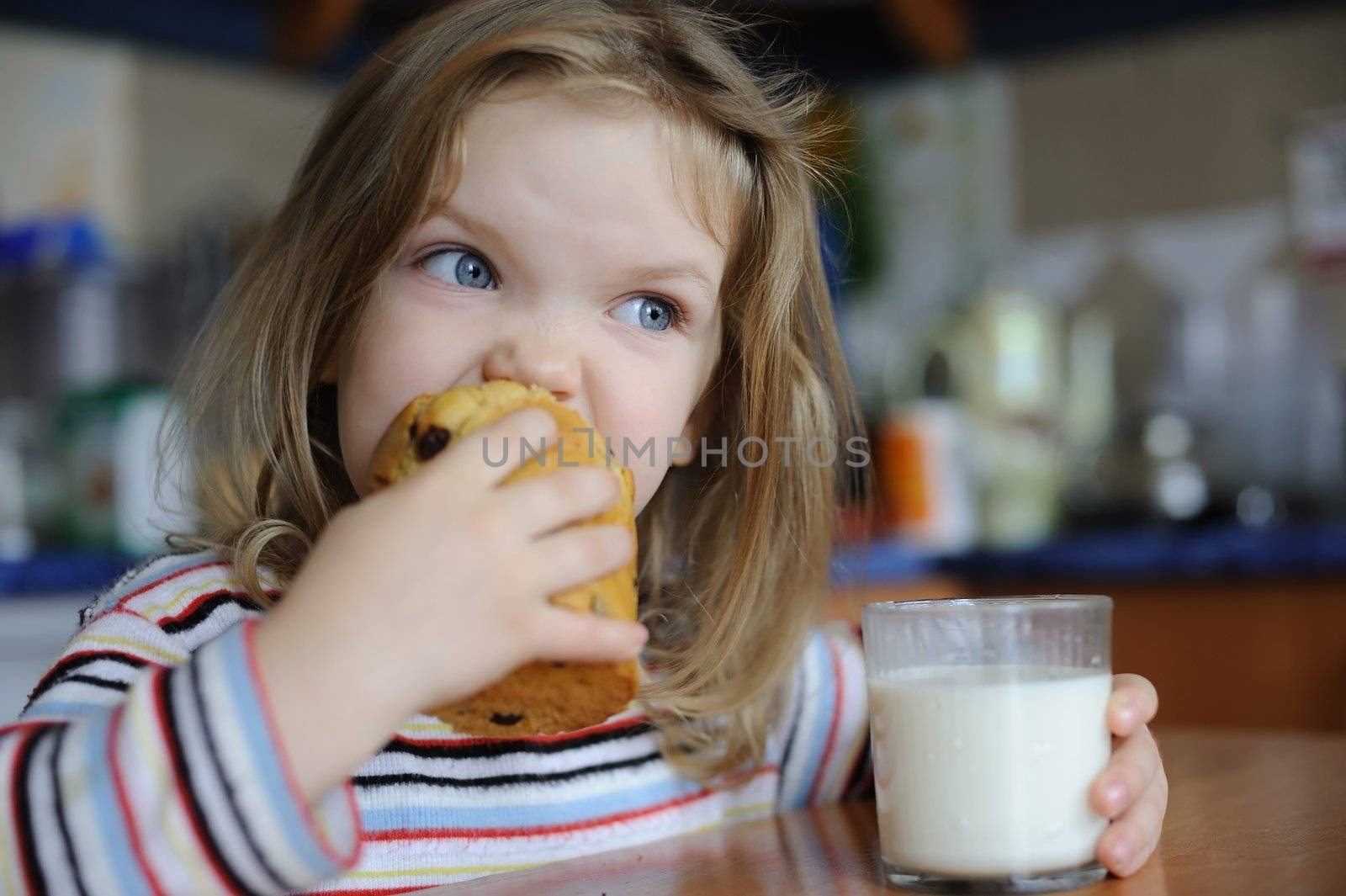 An image of a girl eating cookie with milk