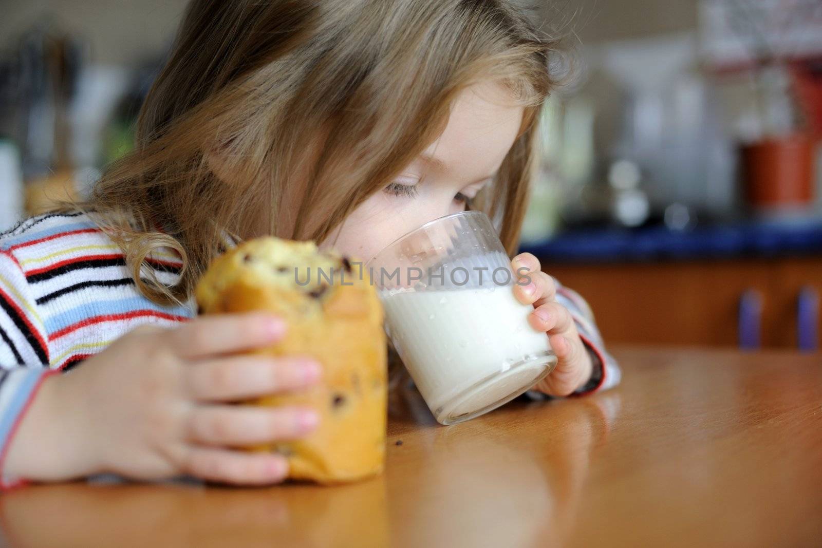 An image of a girl eating sweet cookie with milk