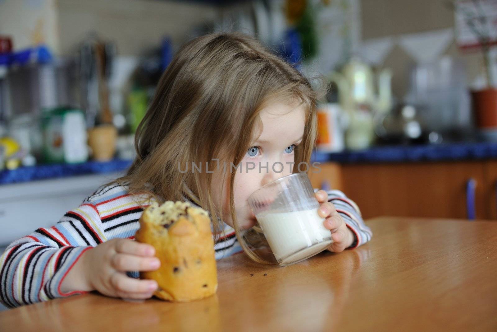An image of a girl eating cookie with milk