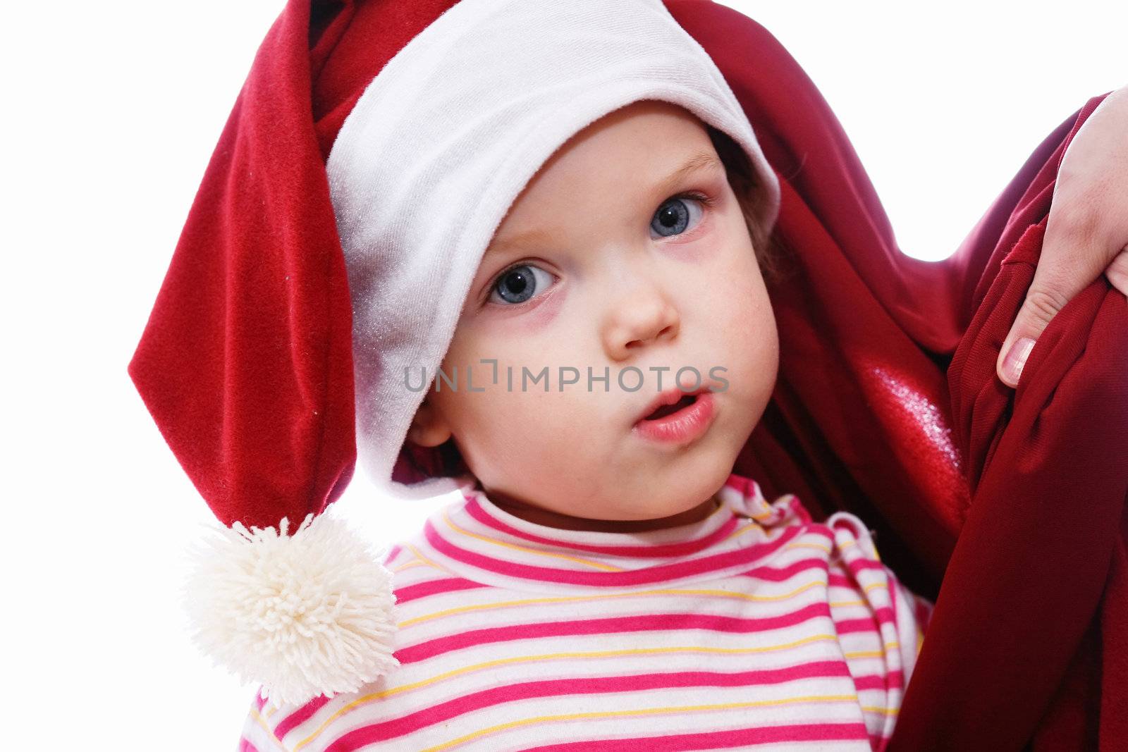 Baby in red hat looking into cristmas bag