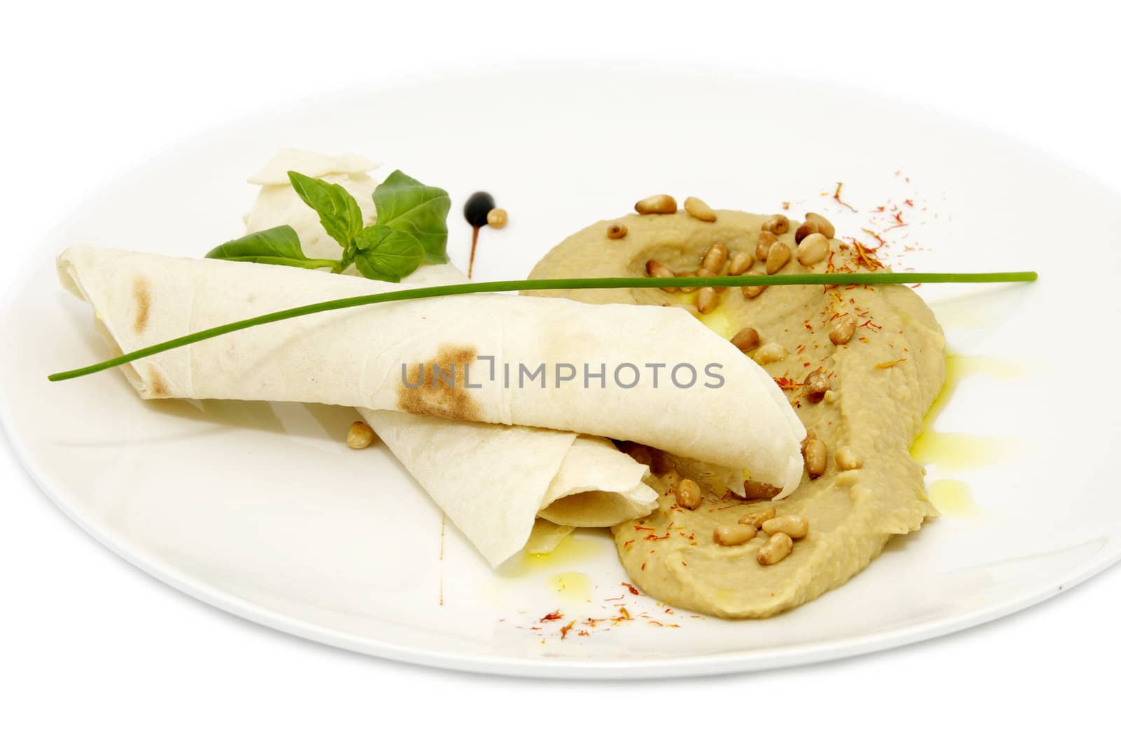 pea soup with bread and herbs on a white plate