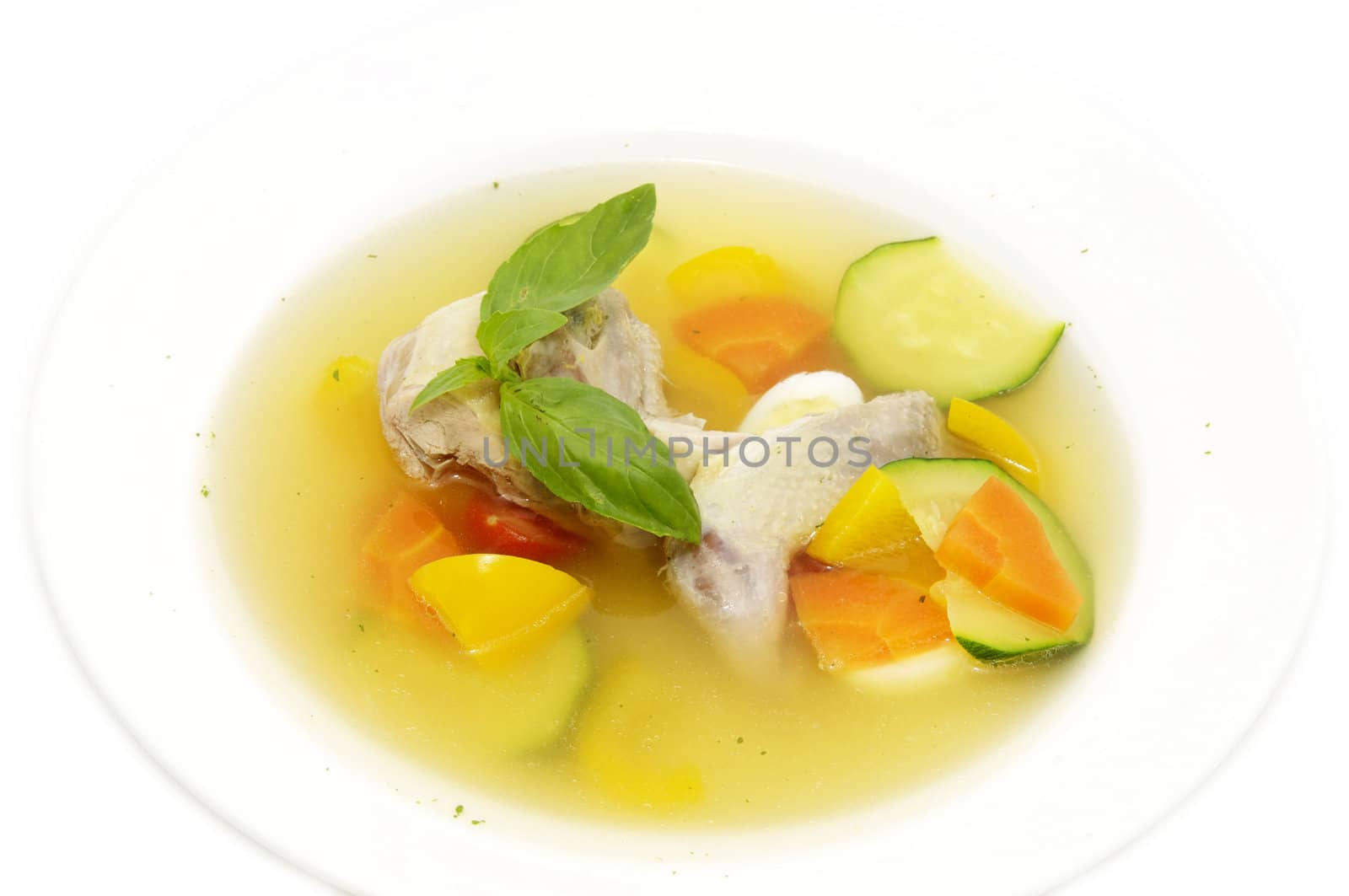 quail broth with vegetables and herbs on a white background
