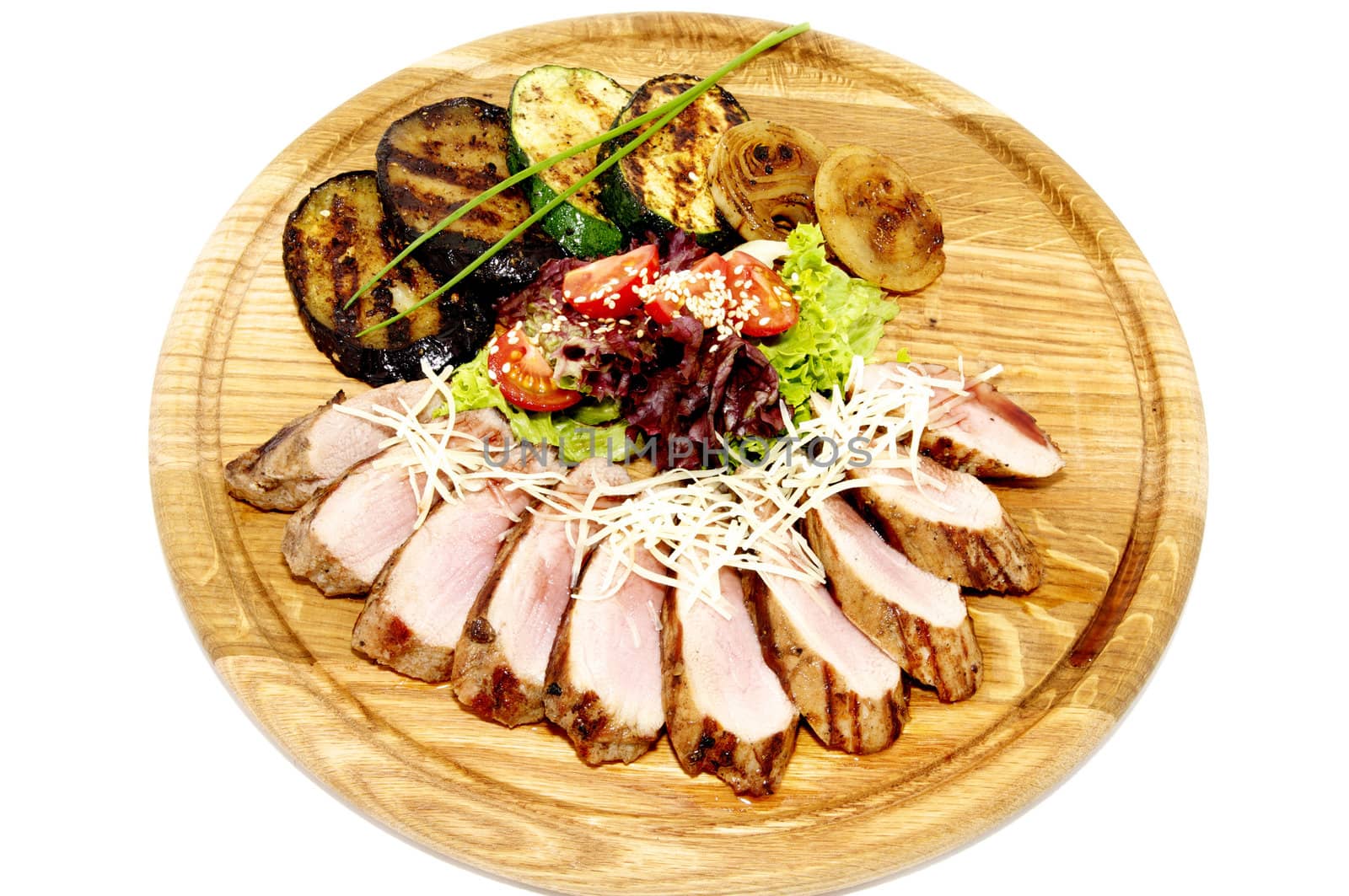 grilled meat with vegetables and herbs on a wooden plate