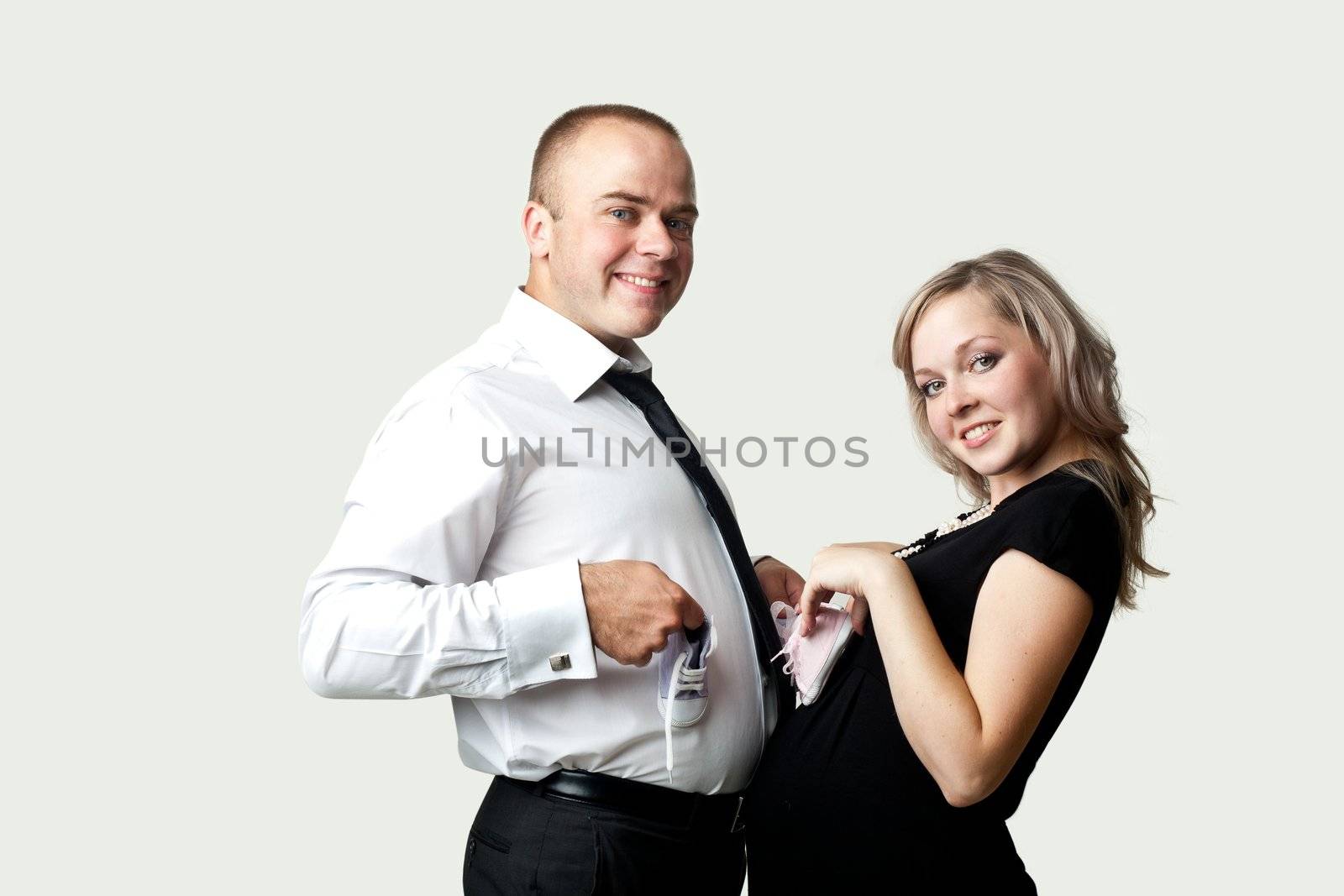 An image of a pregnant woman and her husband with little shoes