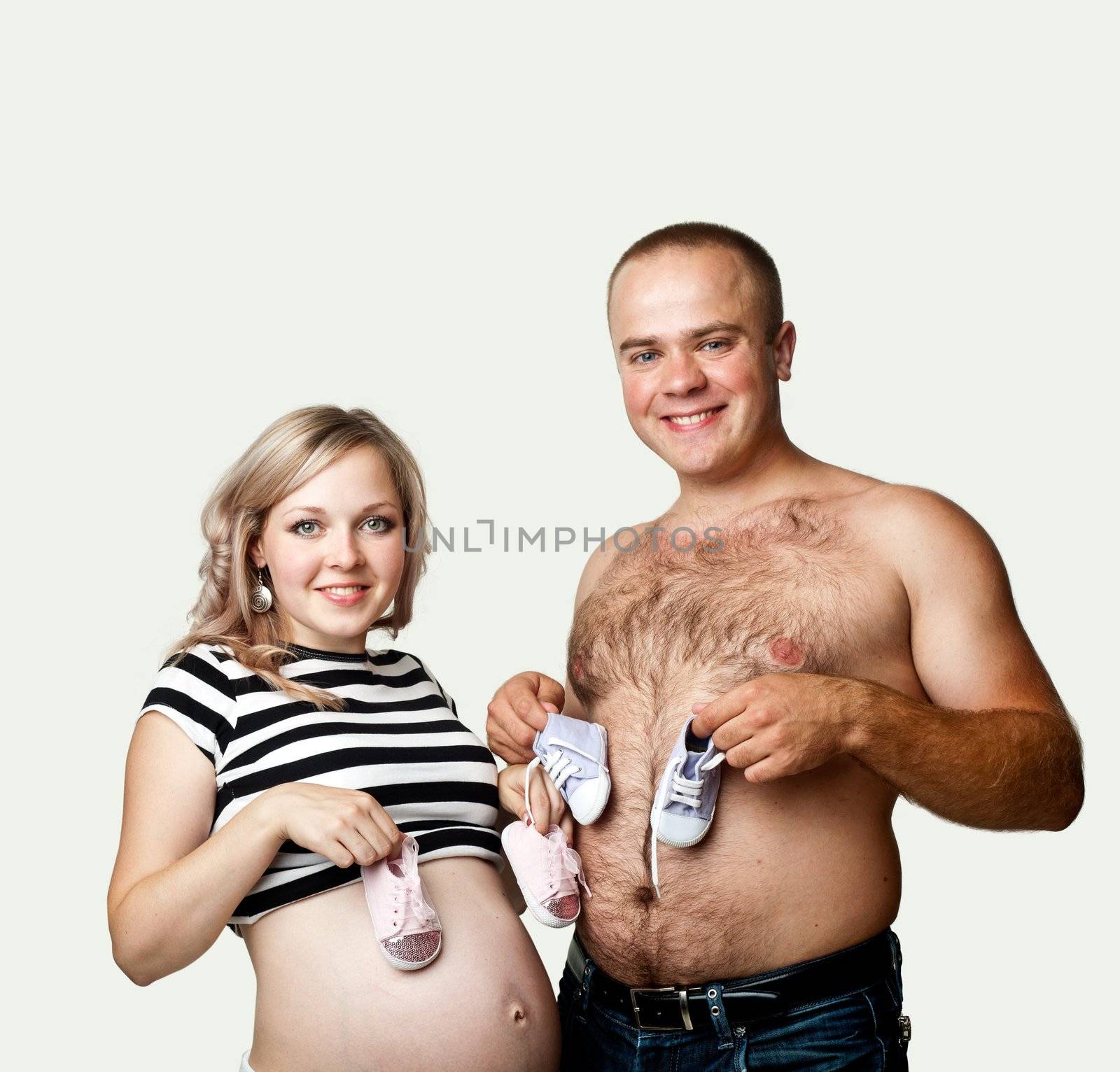 A young pregnant woman and her husband with little shoes