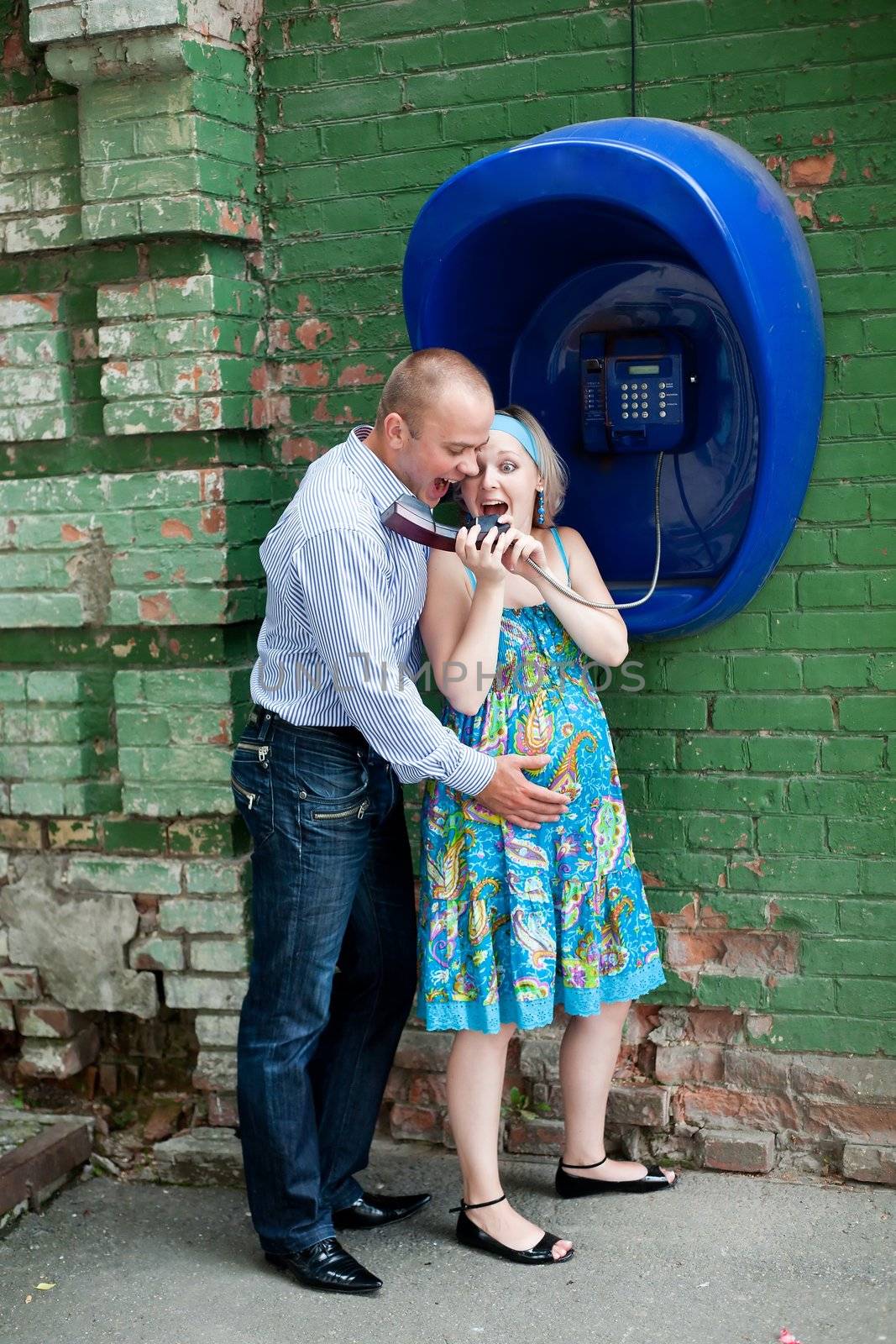 An image of a young couple at telephone in the street