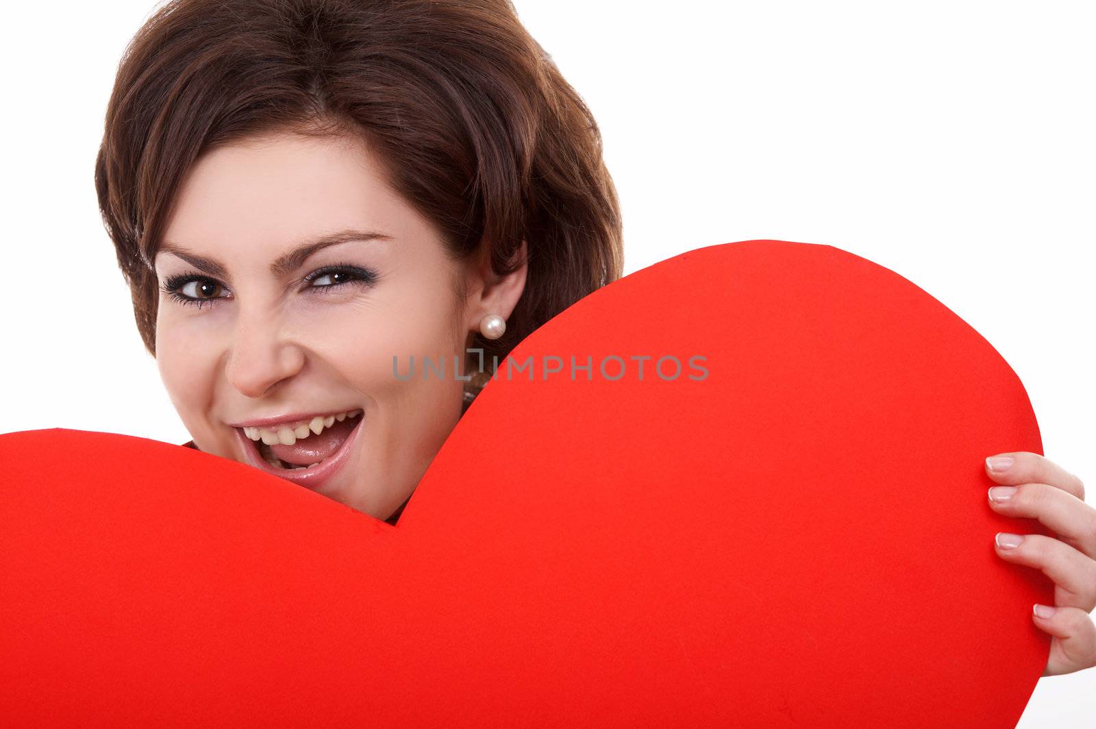 A woman biting a big paper heart