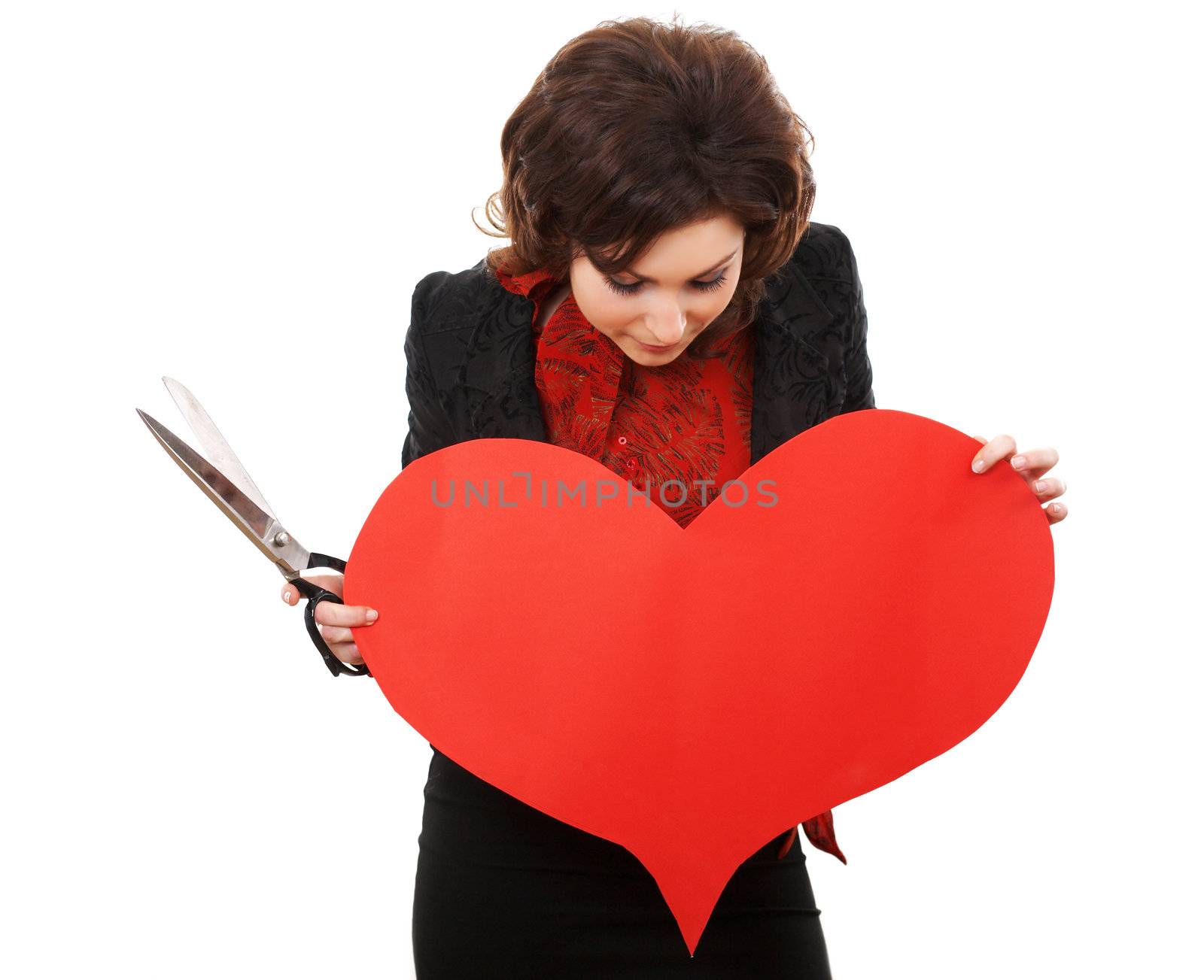 Girl with scissors looking onto a paper heart