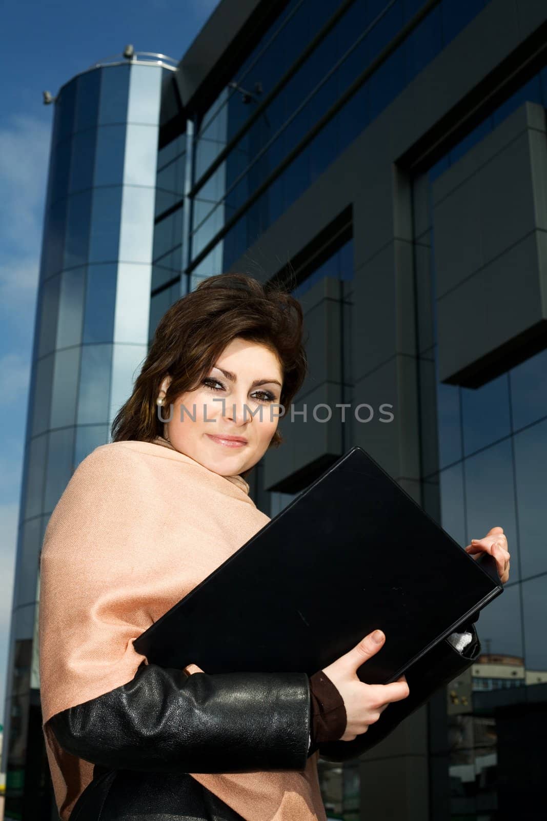 An image of a girl with notebook on background of building