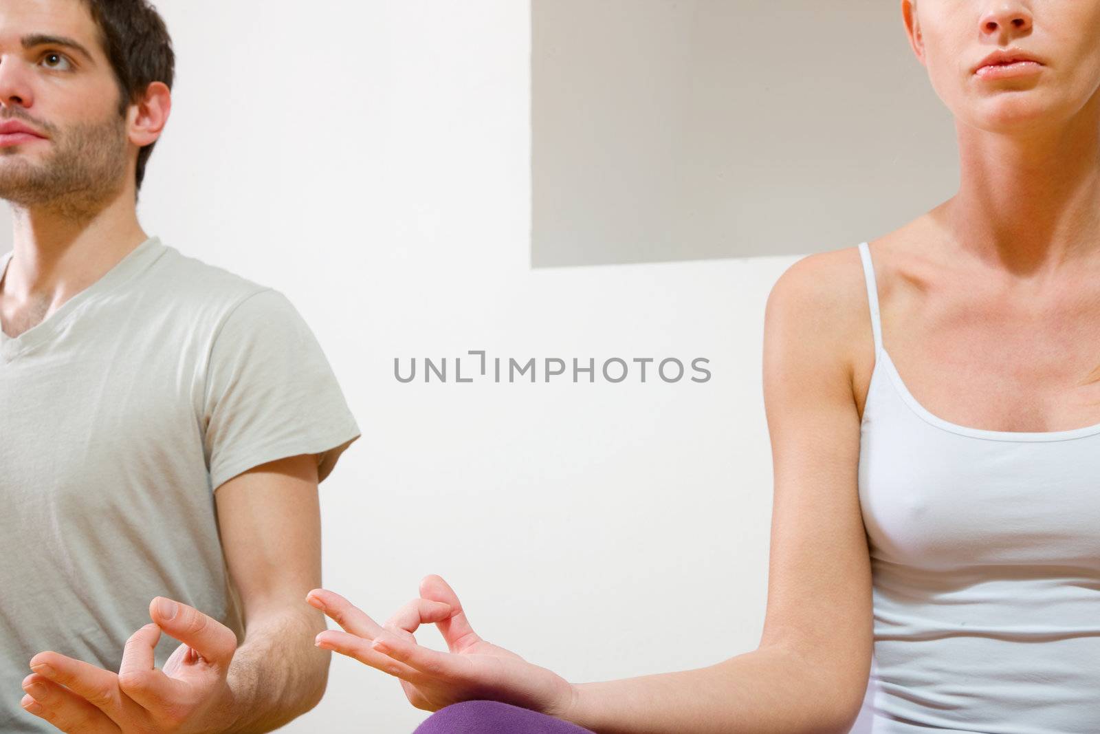 couple sitting on floor doing yoga by ambro