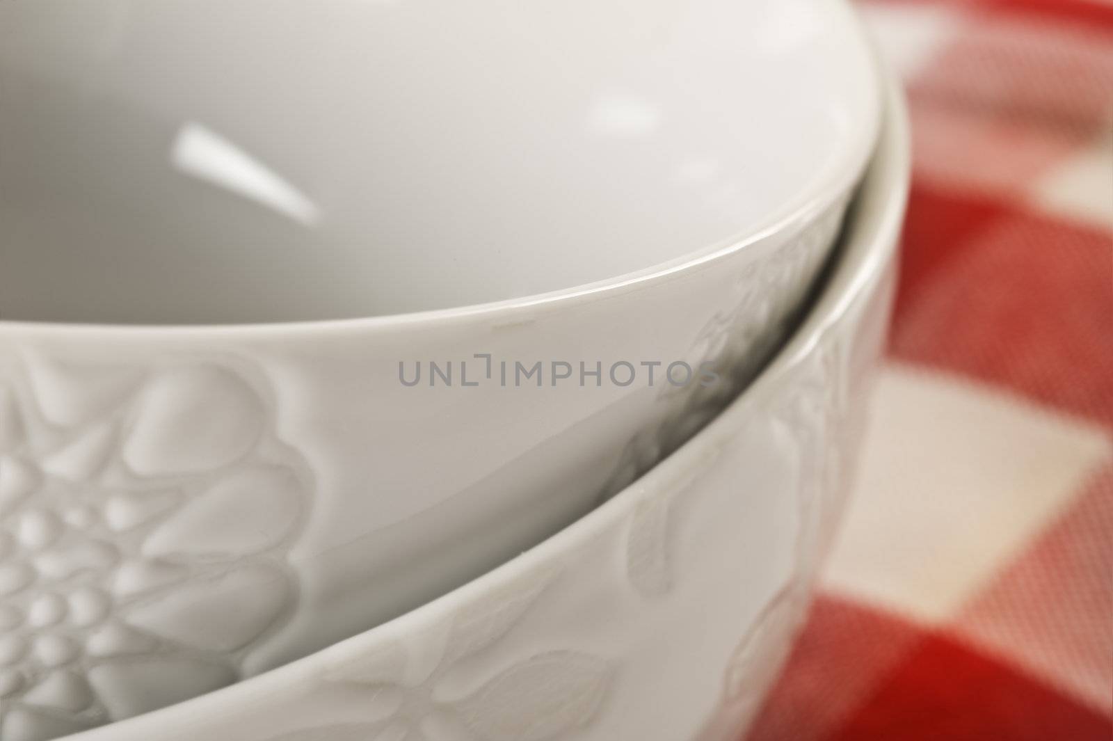 Close up of 2 white bowls - focus on top bowl with very shallow depth of field