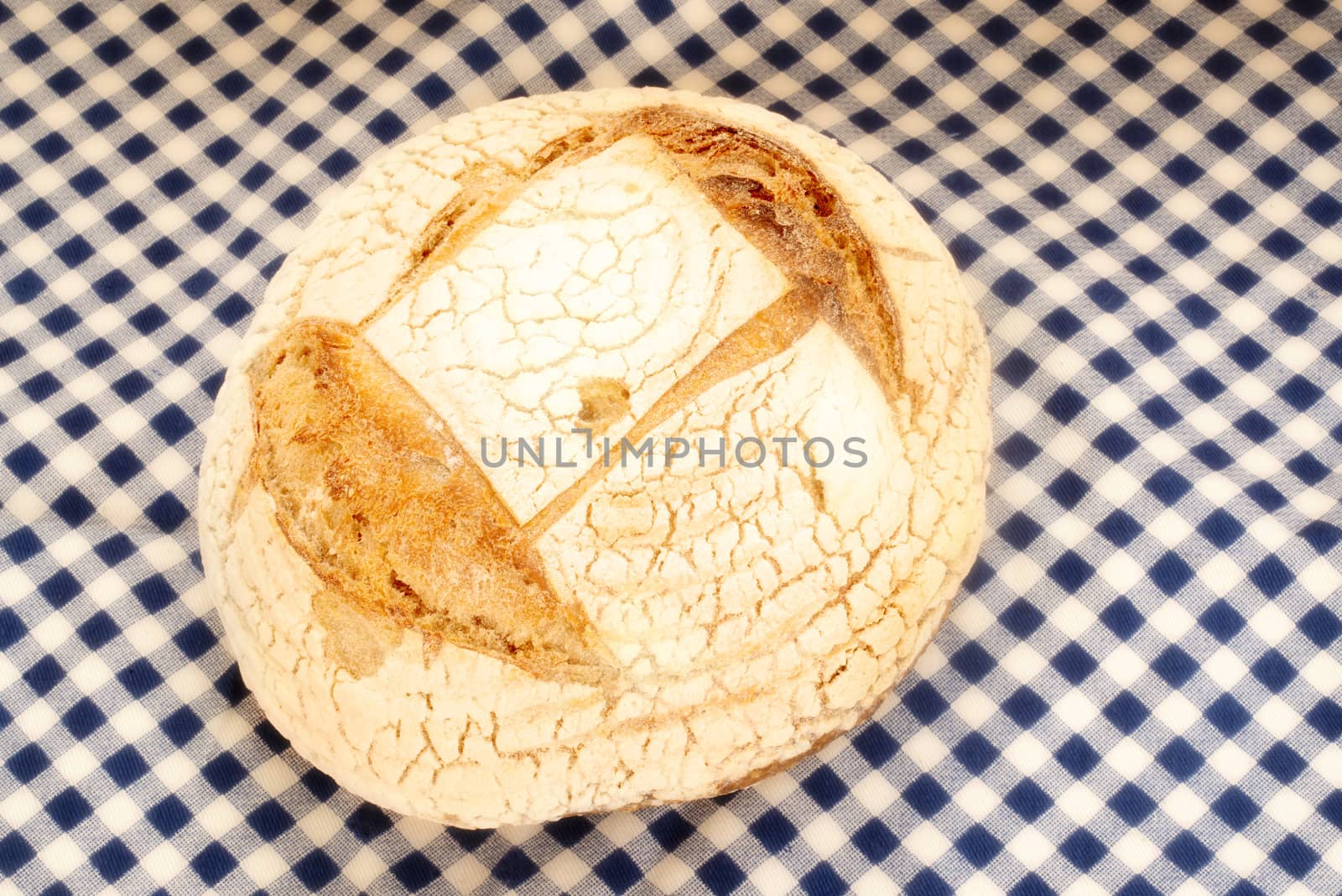 rustic organic bread made by hand on a blue checkered tablecloth