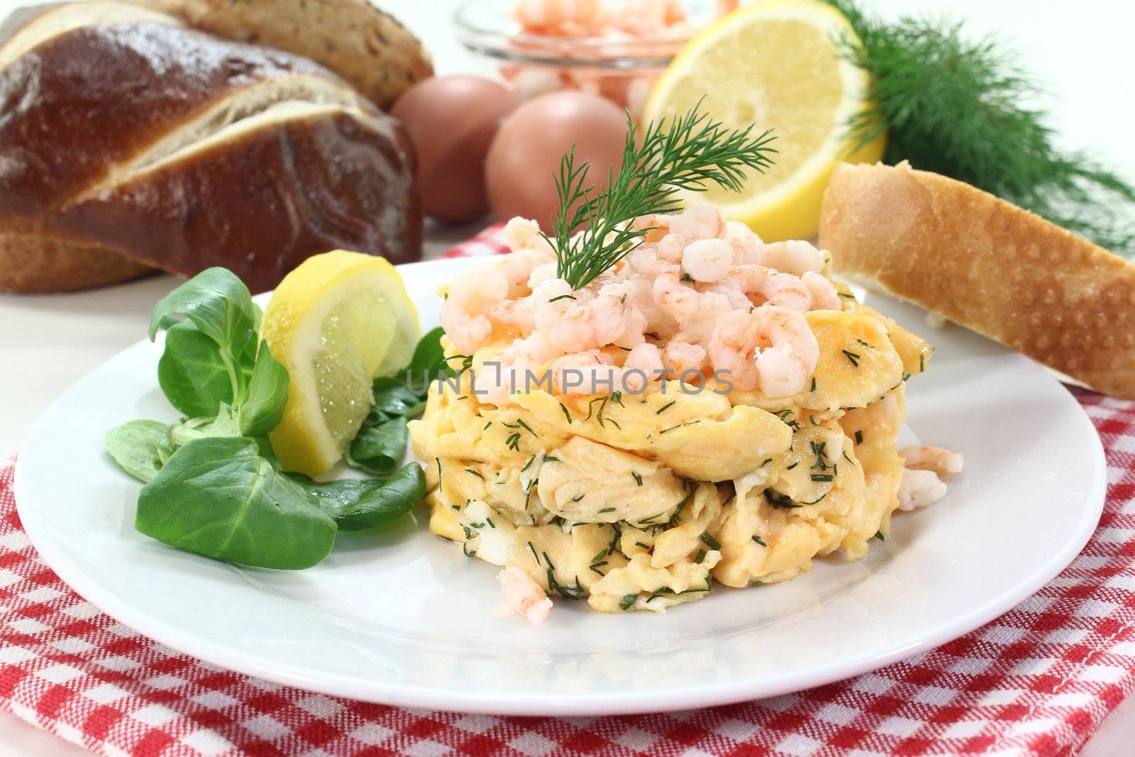 Scrambled eggs with shrimp, dill and corn salad on a plate