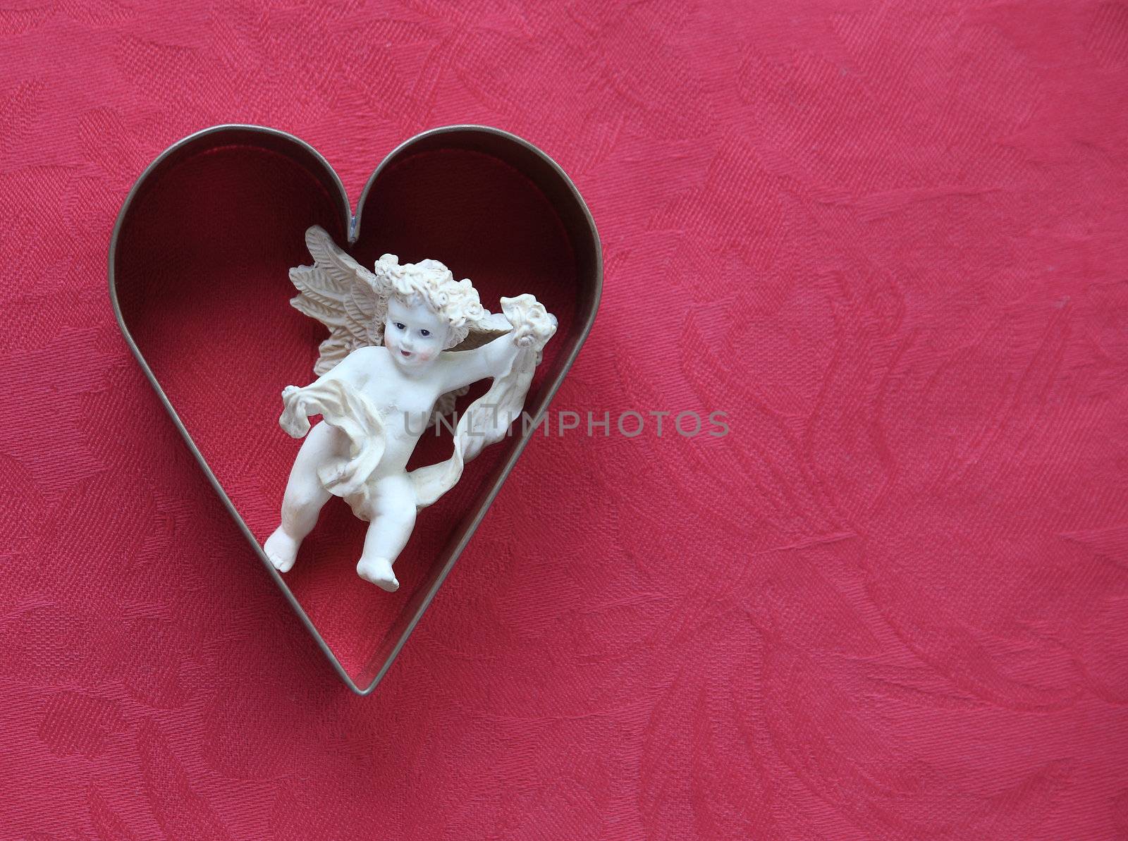 heart-shaped cookie cutter with a figure of cupid inside