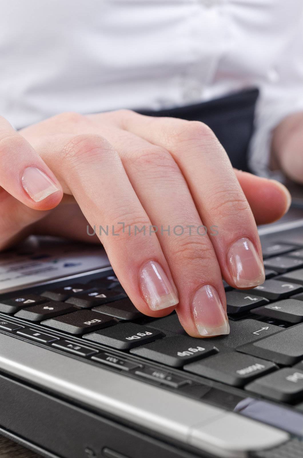 woman pressing enter key on the laptop computer keyboard, selective focus on key-press