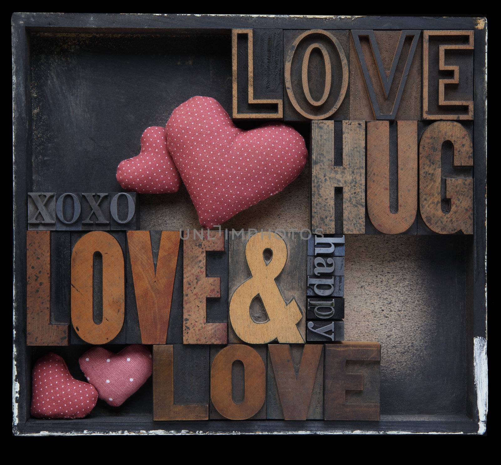 love and related words in wood and metal letterpress type with fabric hearts in a box