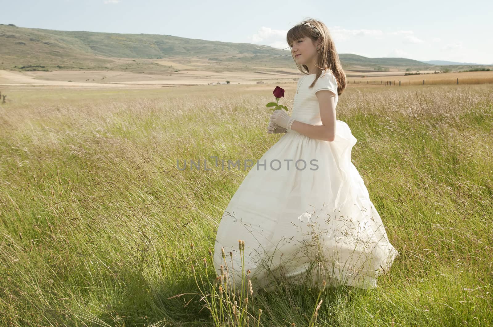 girl wearing first communion dress in the meadow