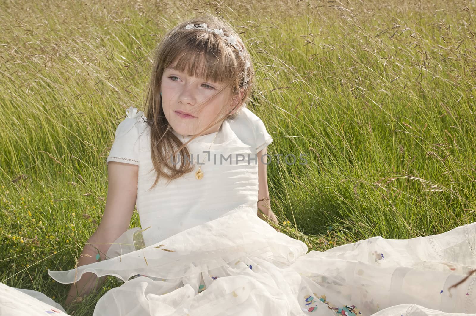 girl wearing first communion dress in the meadow