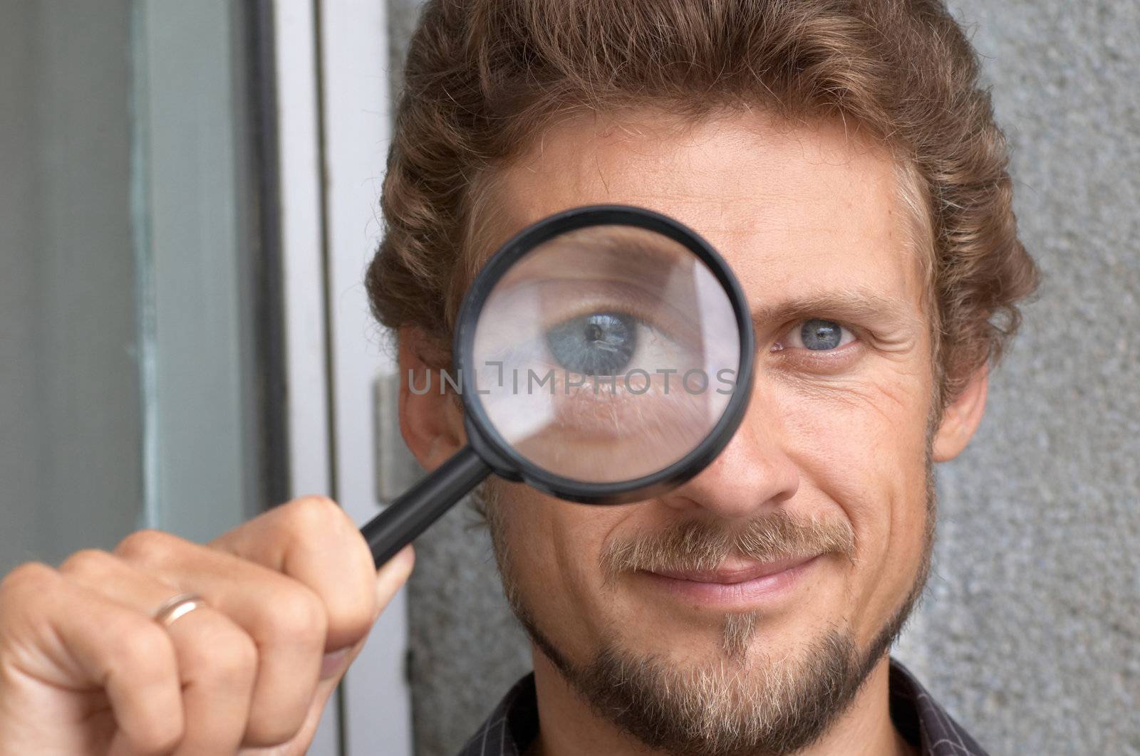 Portrait of a young man with a magnifying glass