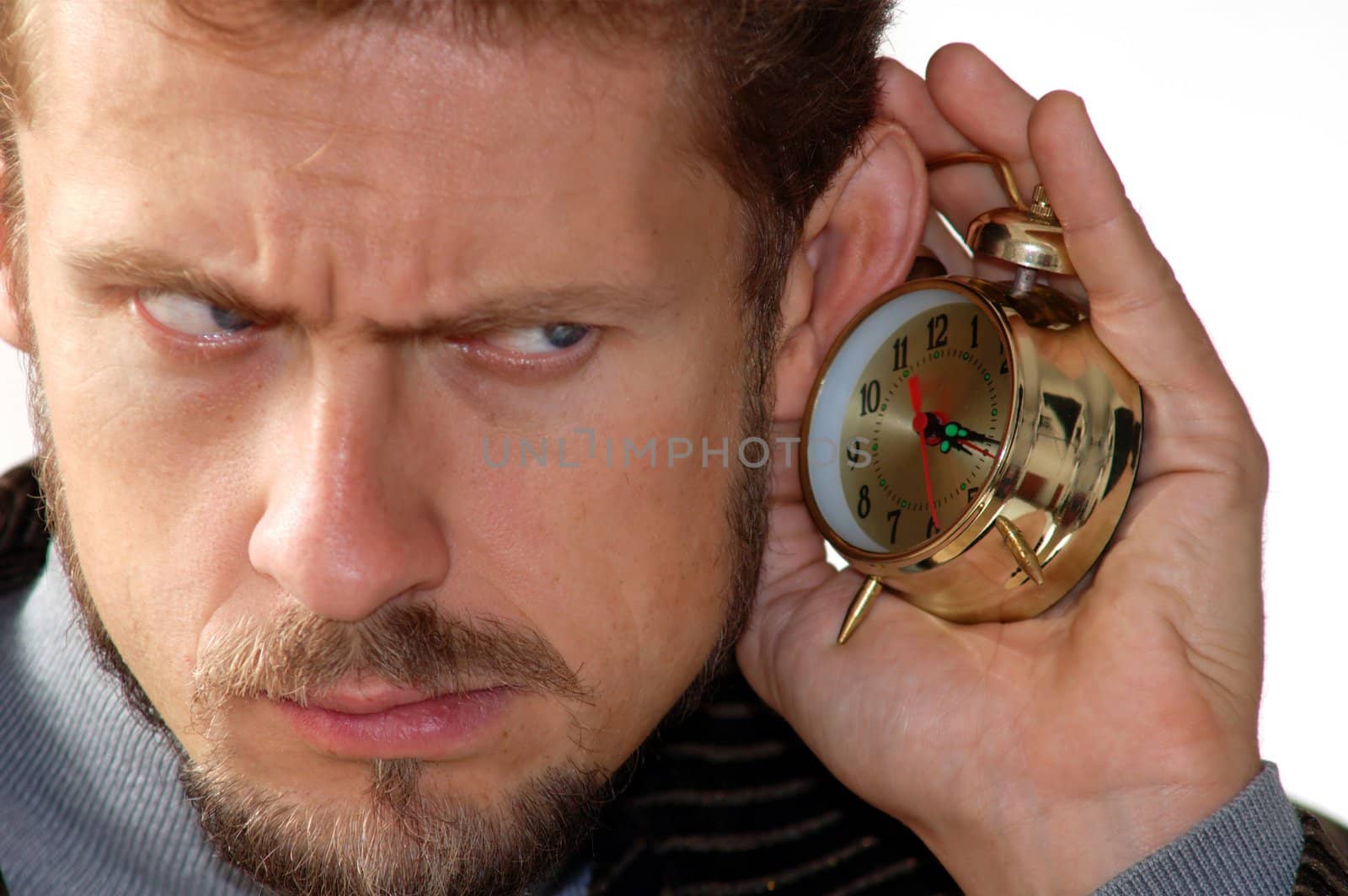 A man listening to an alarm clock sound