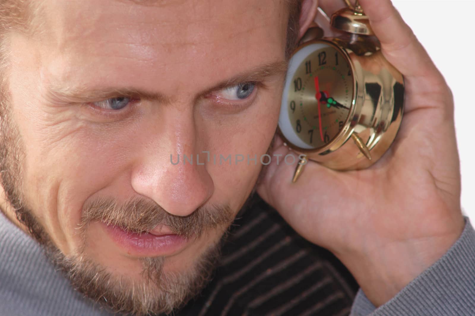 A businessman listening to an alarm clock sound