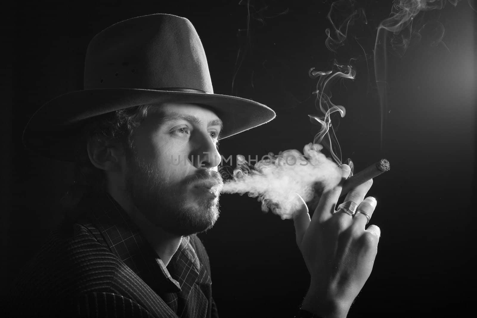 A man with a cigar making puffs of smoke