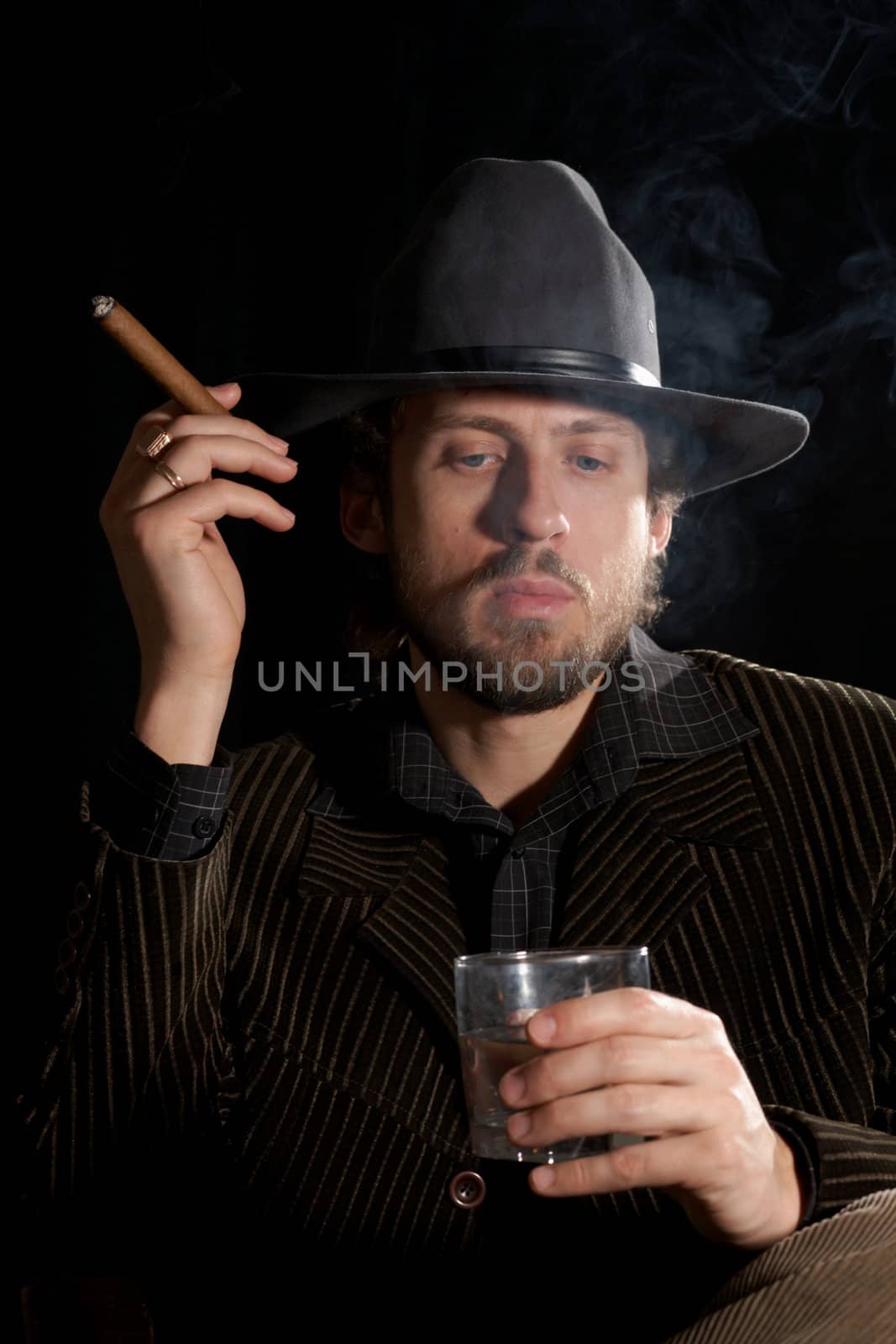 An image of bearded smoker in dark room