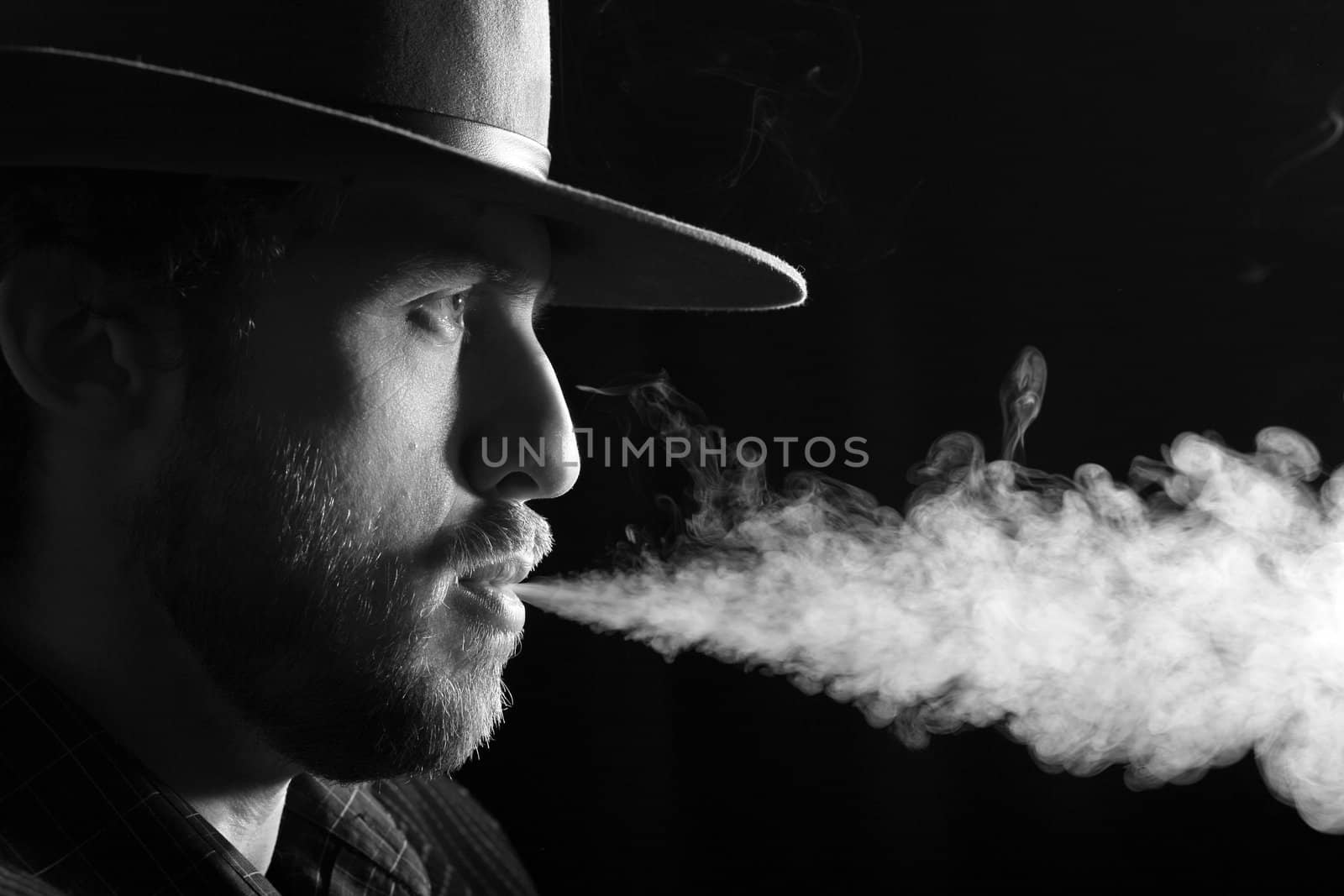 An image of a smoking man on dark background