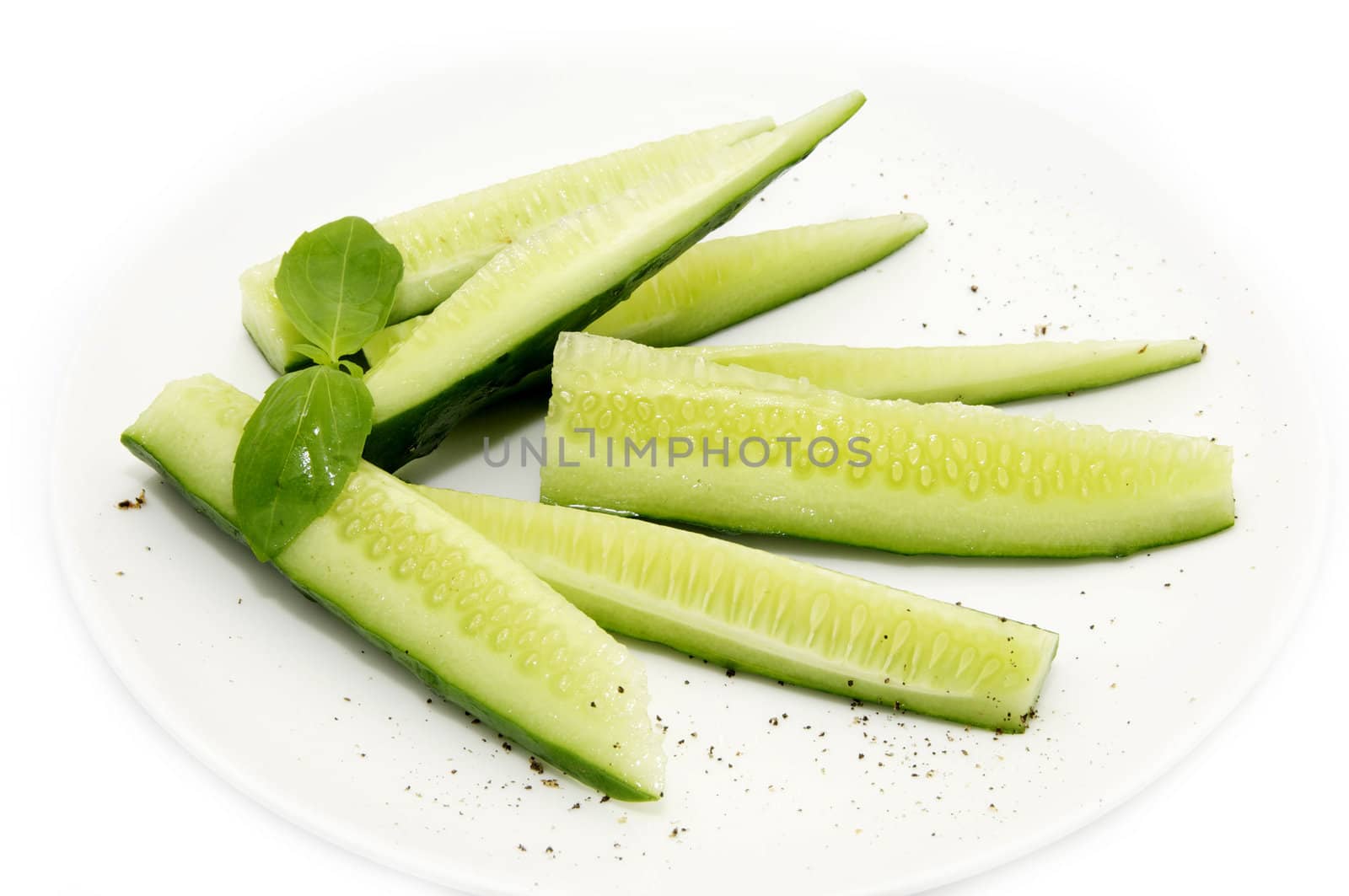 sliced cucumber on a plate on a white background