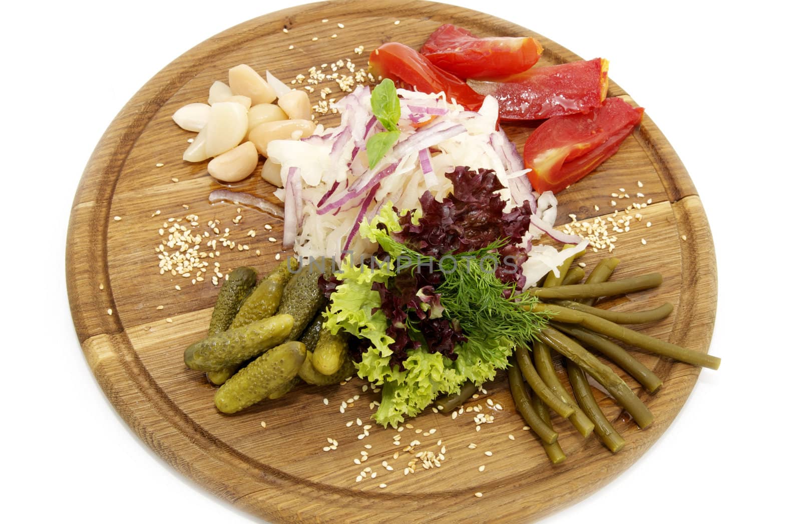 wooden plate with pickles on a white background
