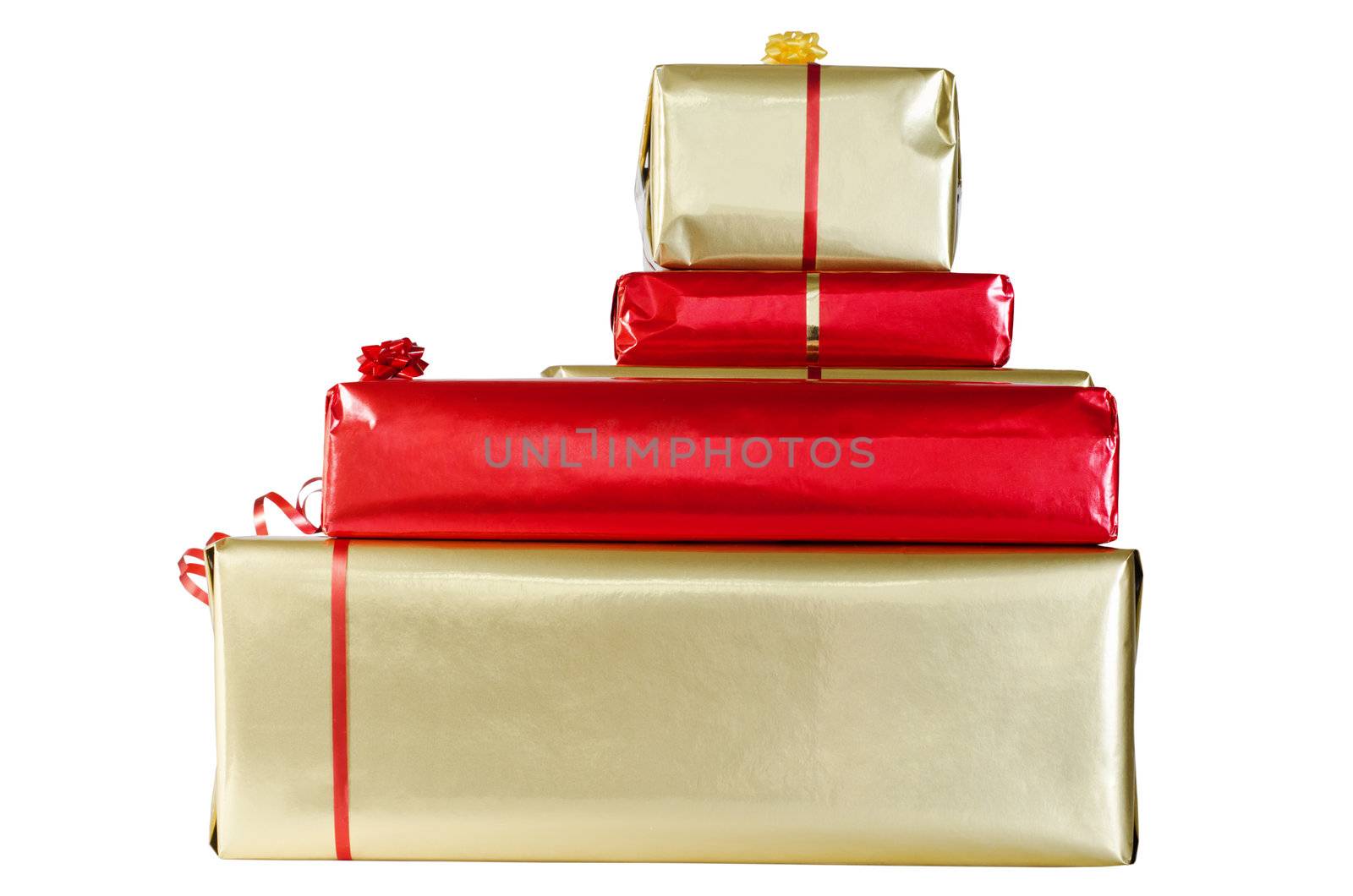 A pile of Christmas gift boxes, wrapped in red and gold paper and decorated with ribbon and rosettes, isolated on a white background.