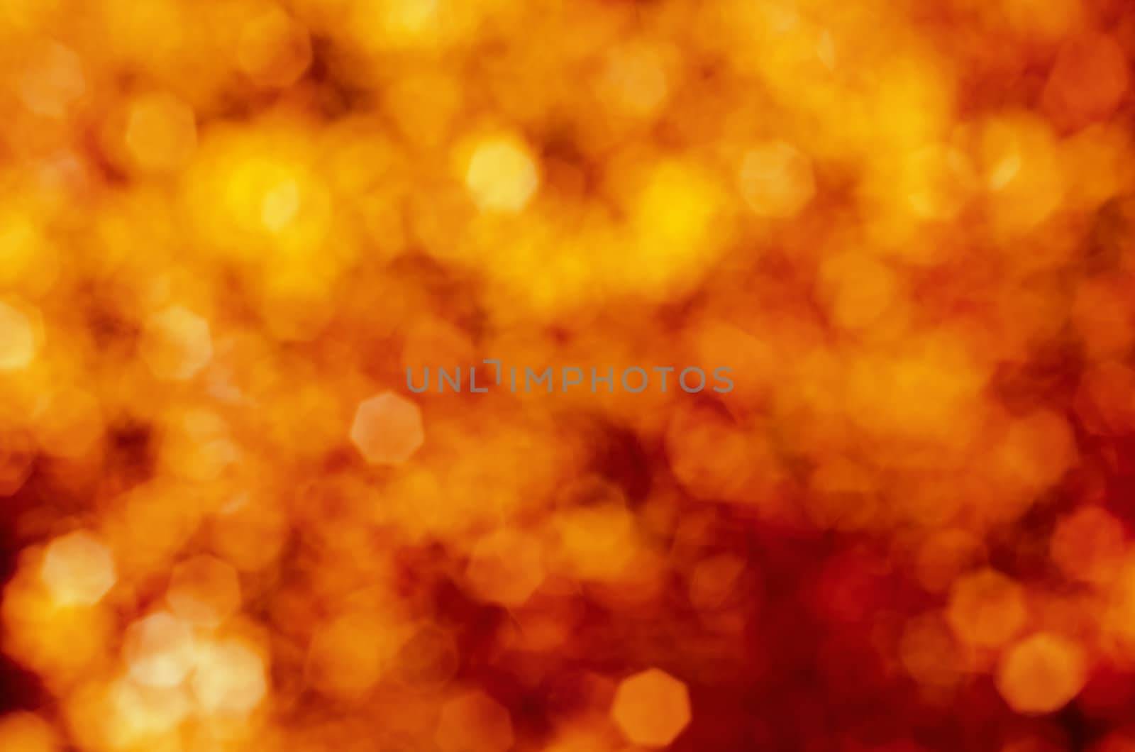 Soft, blurry, photographed bokeh background of reds and yellows, giving a fire-like, explosive effect.  