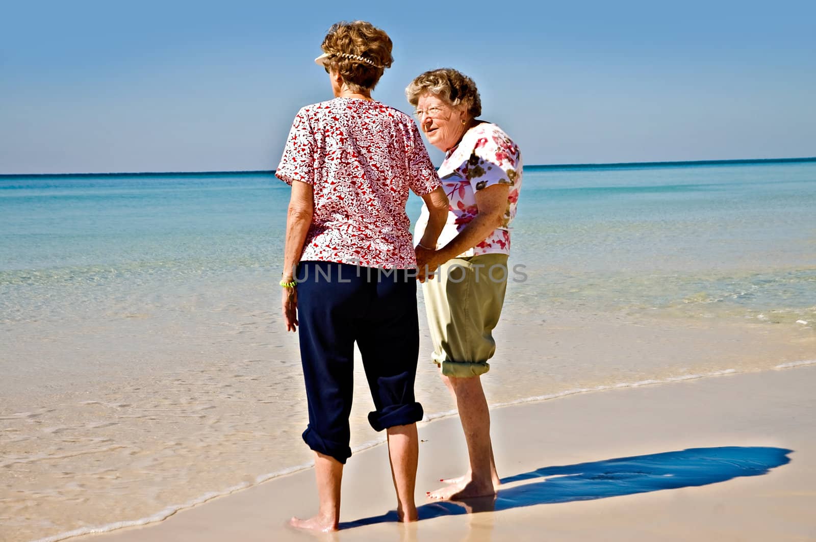 Two beautiful elderly women enjoying the beach.