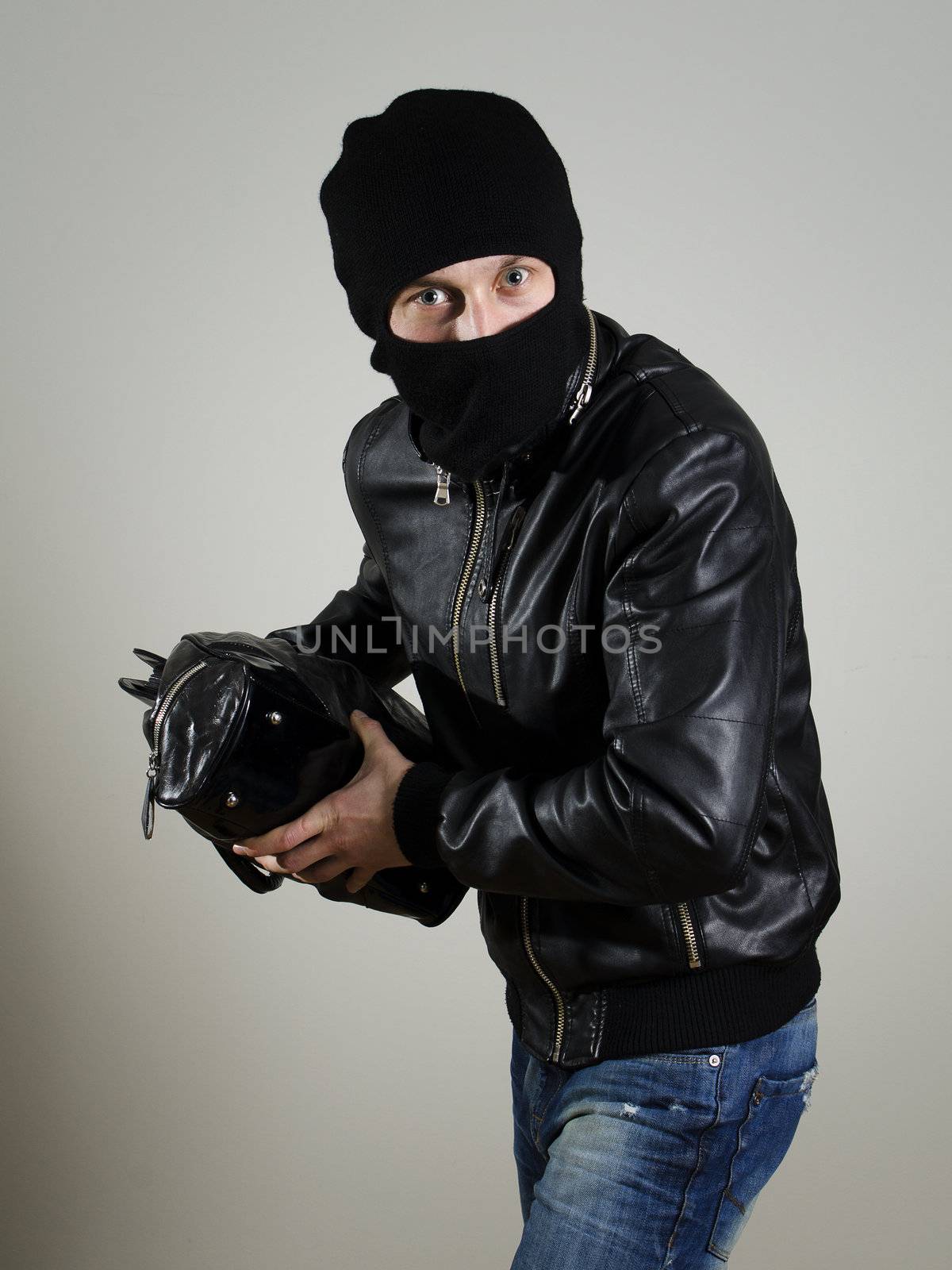 Portrait of male burglar with a handbag.