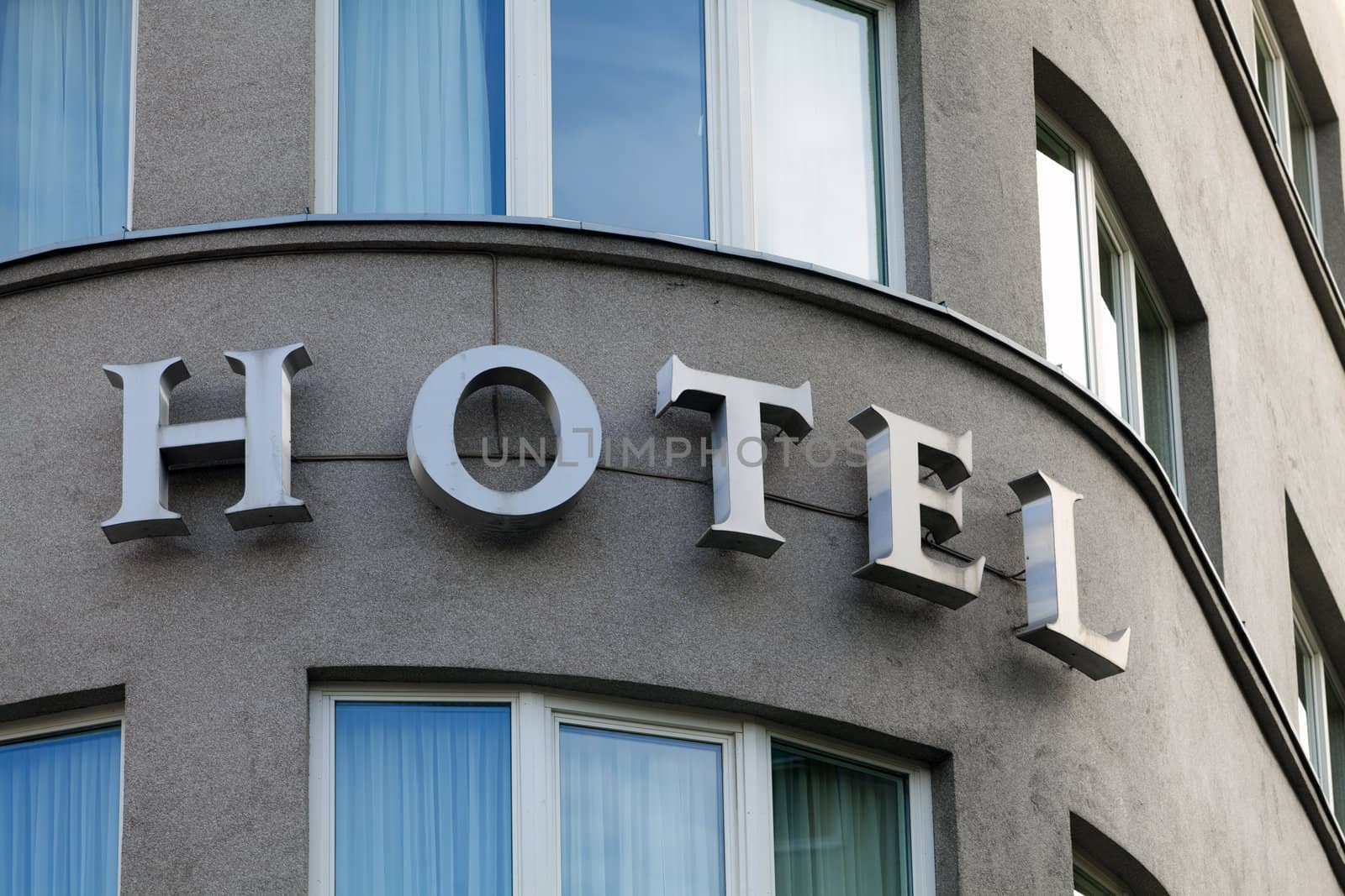 Hotel sign in exterior view on a rounded front of building by Portokalis