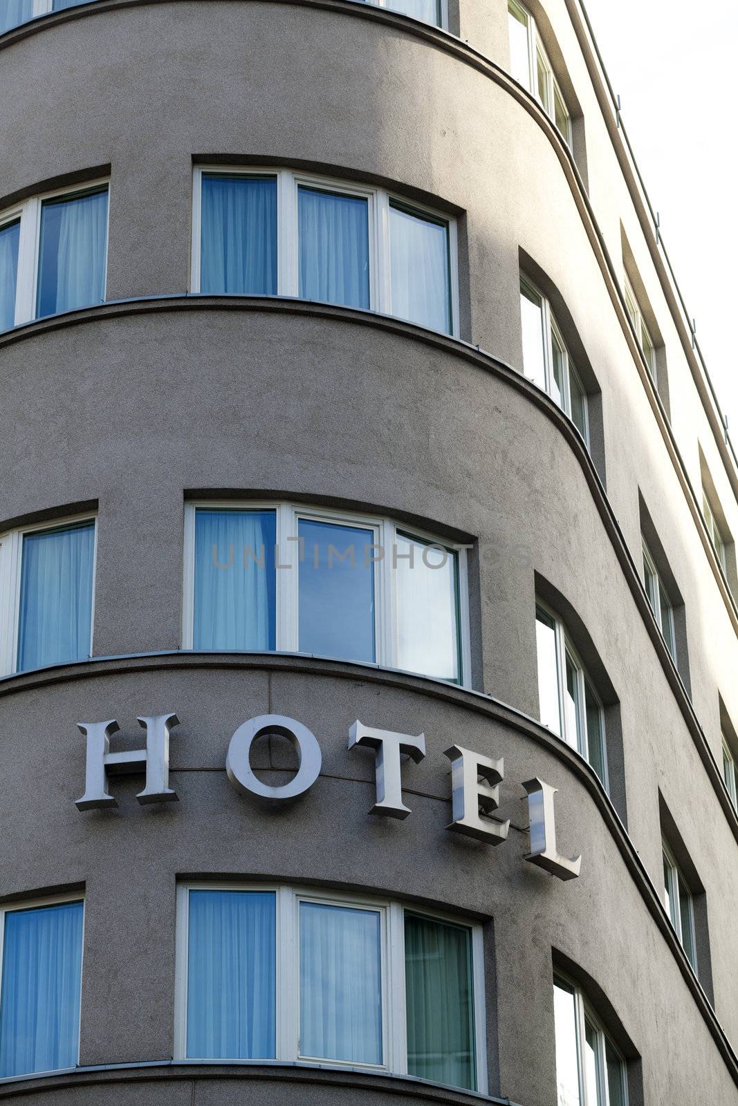 Hotel sign in exterior view on a rounded front of building by Portokalis