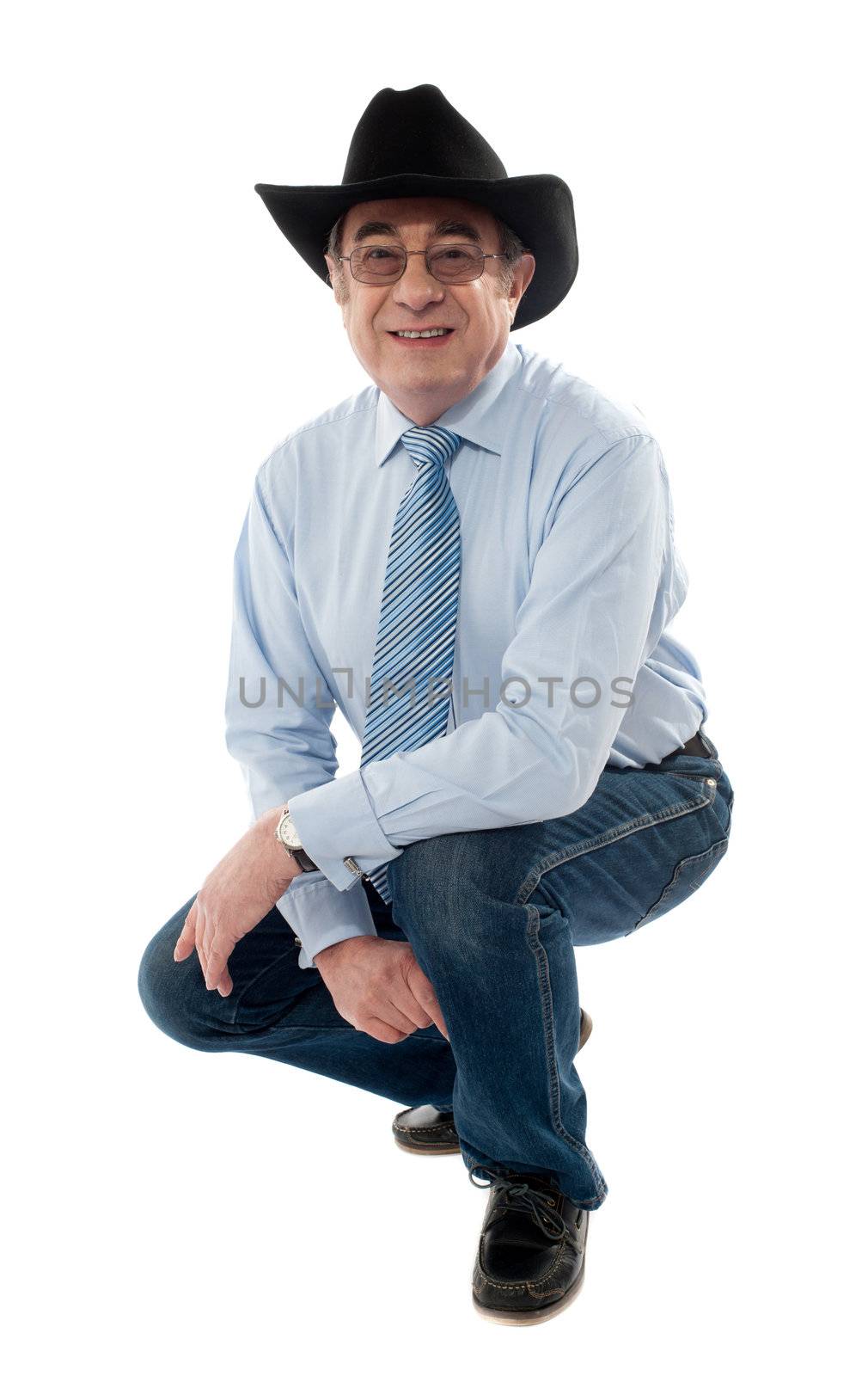 Image of a senior cowboy posing semi seated isolated on white