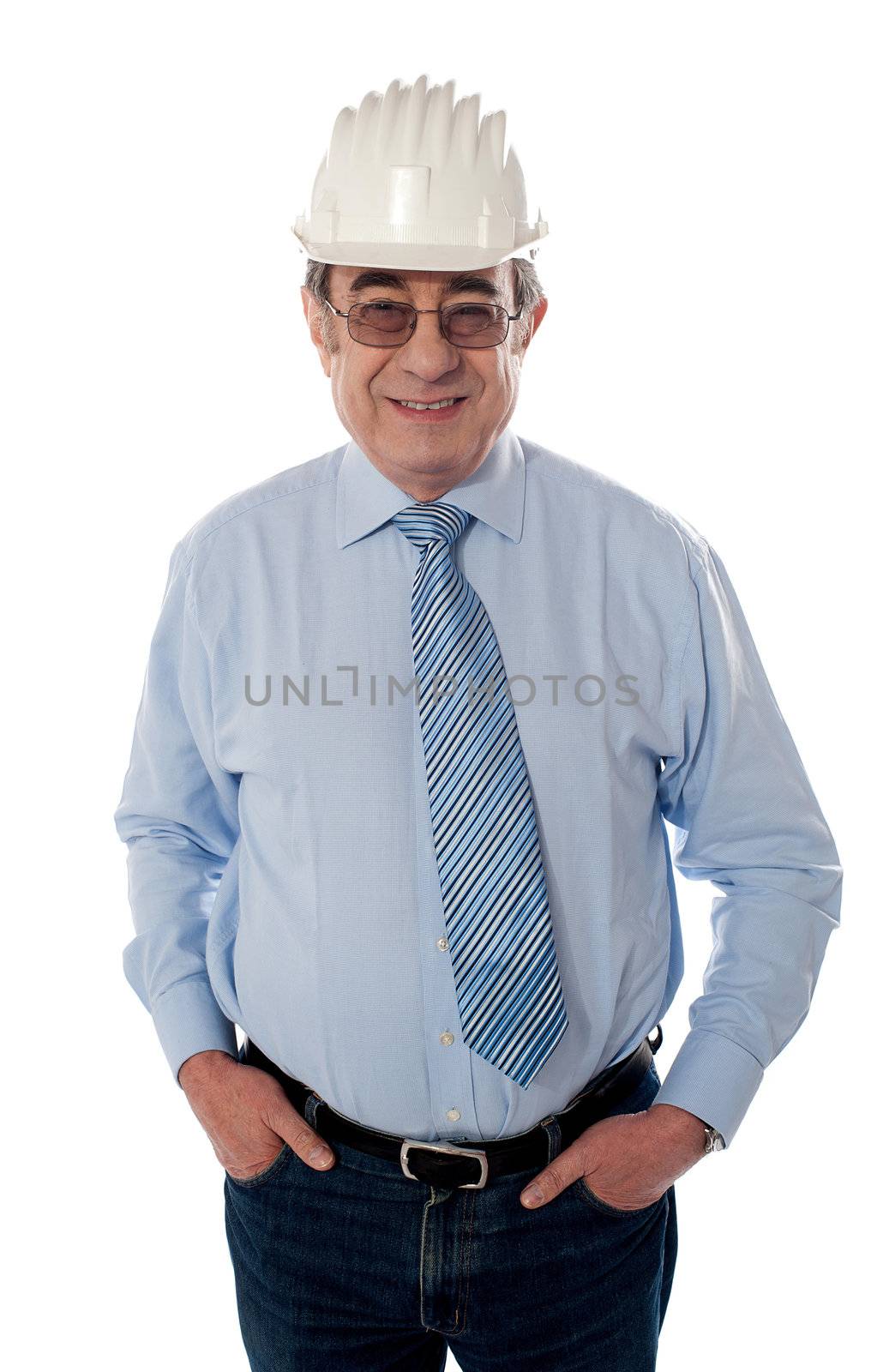Aged builder posing with arms in pocket, smiling on white background