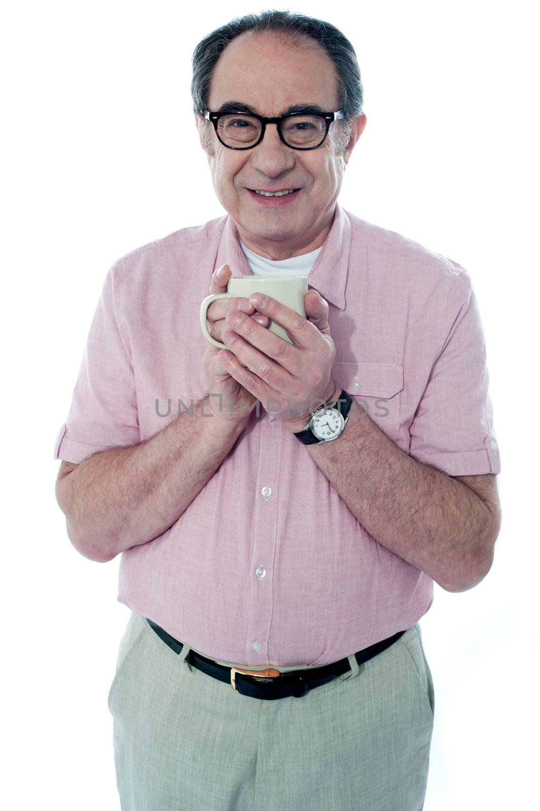 Old man holding a coffee mug by stockyimages