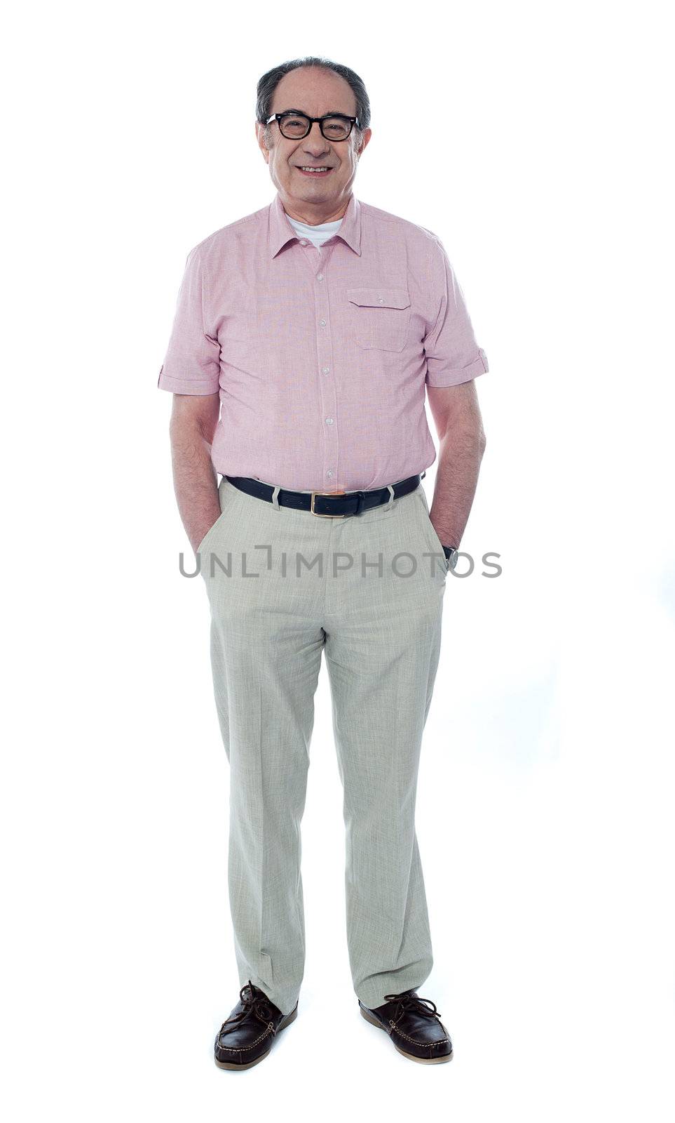 Smiling handsome senior member with hands in his pocket isolated on white