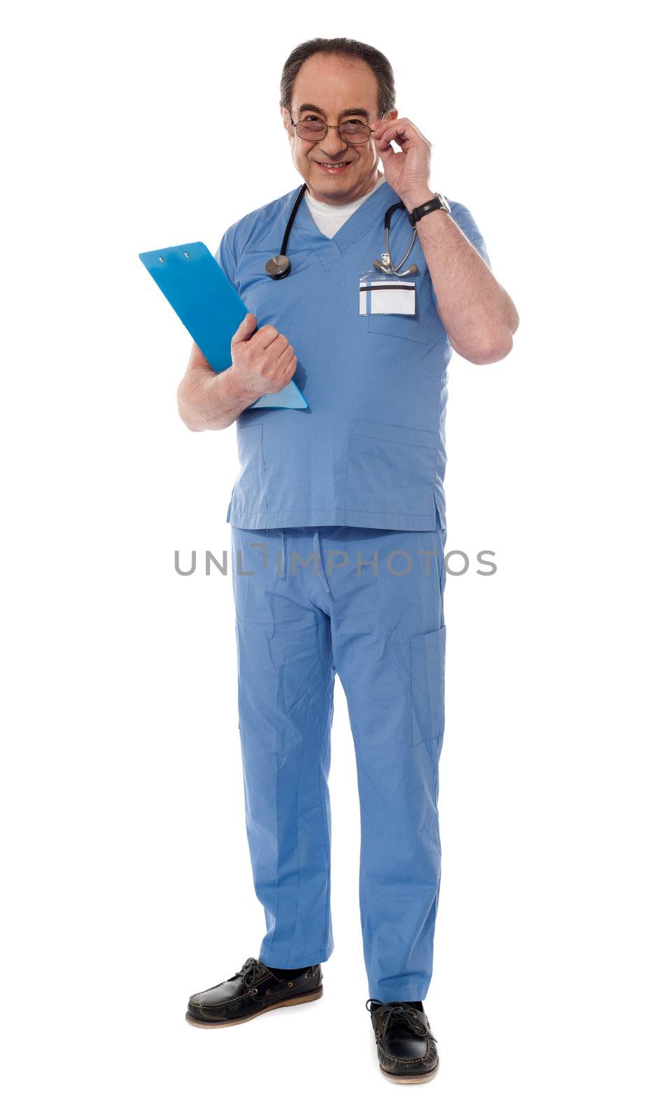 Medical professional looking at camera while holding his eyeglasses
