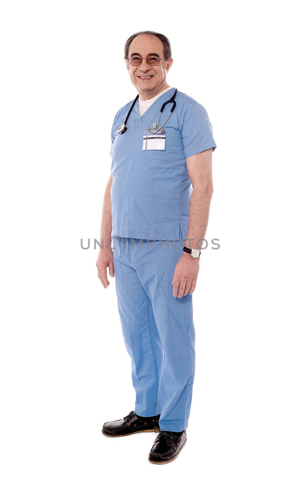 Aged doctor posing with stethoscope around his neck by stockyimages